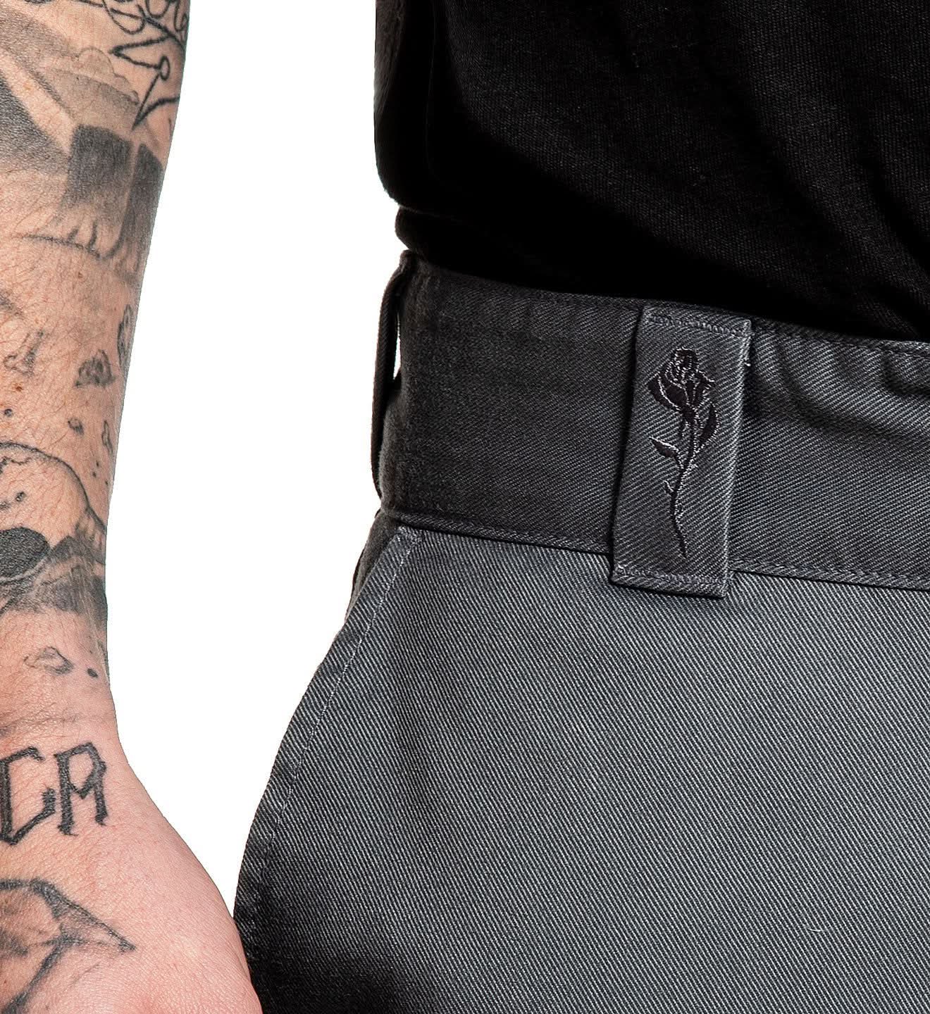 Gray pants with a belt and logo patch on a white background