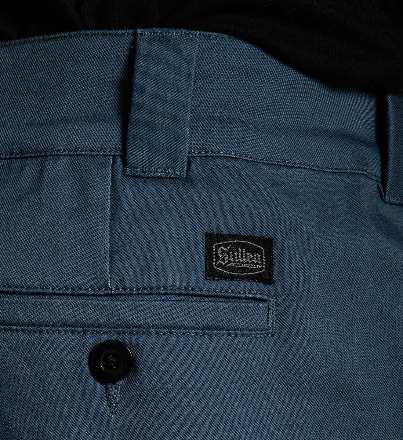 Close-up of a blue jacket with a brand logo on the chest pocket.