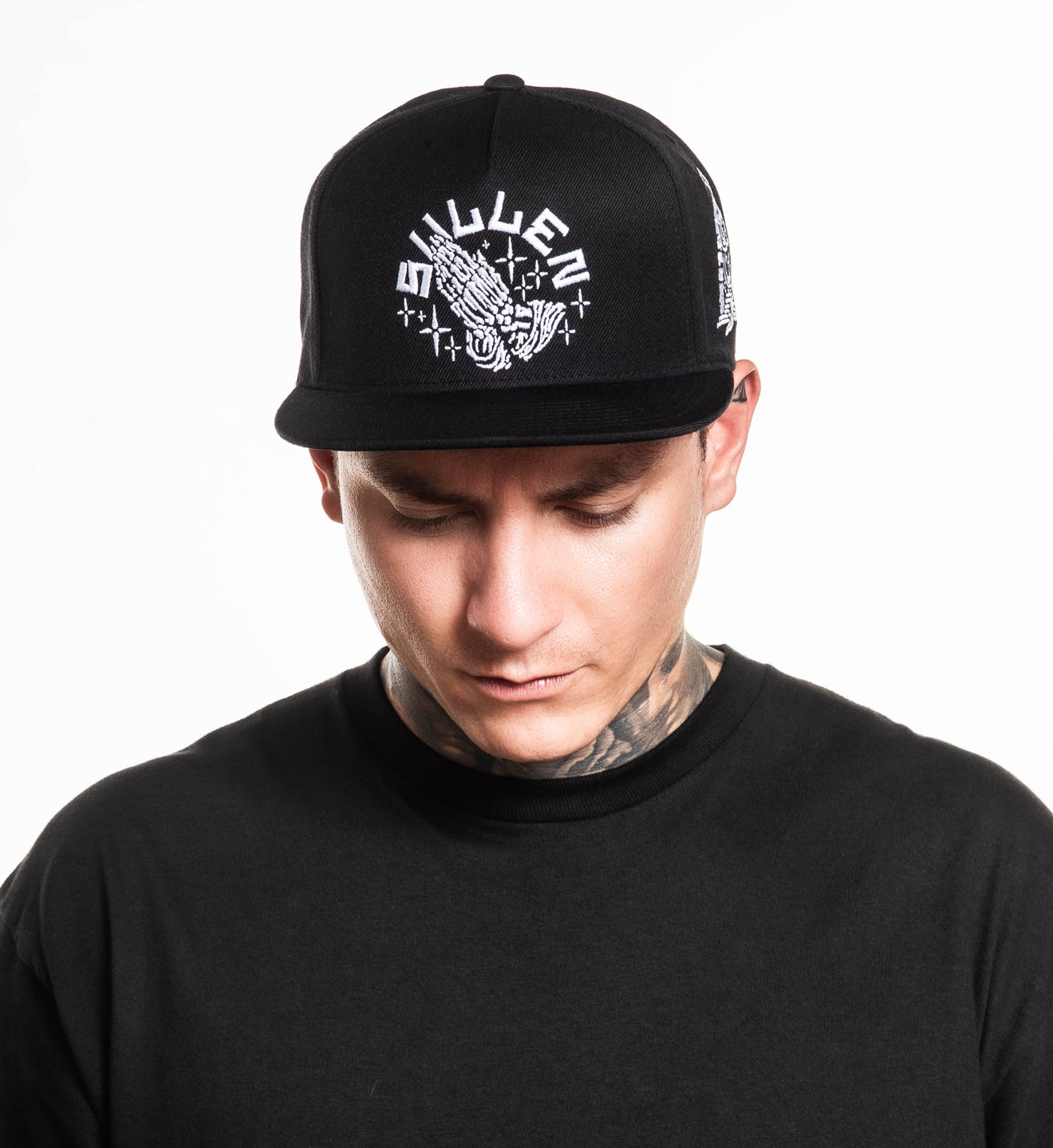 Man wearing a black cap with white logo on a white background