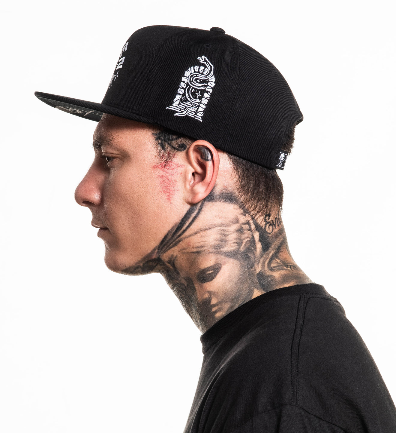 Person wearing a black cap with white designs on a white background