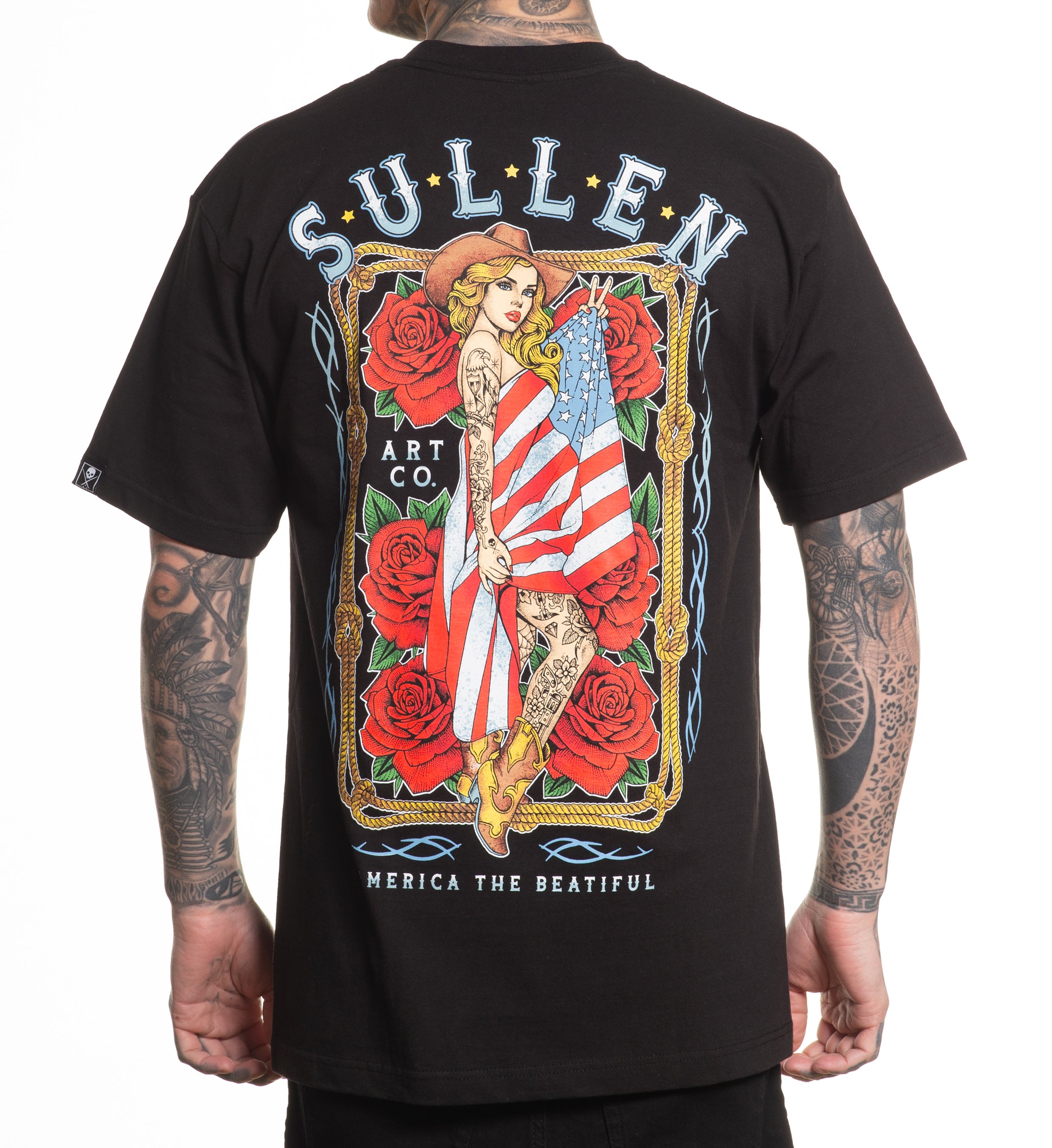 Black t-shirt with a colorful graphic design on the back, featuring an American flag and roses, worn by a person.