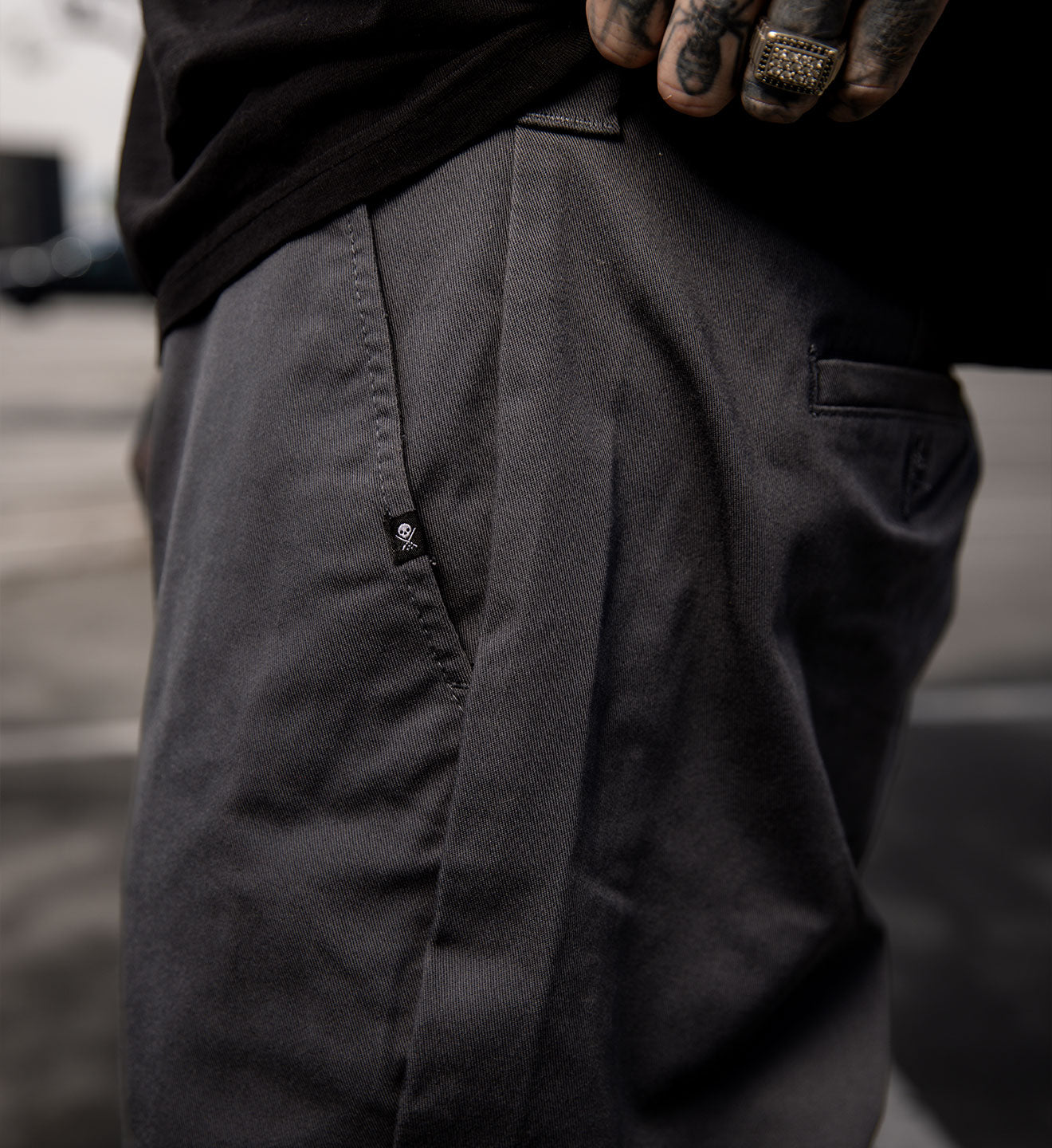 Close-up of dark pants with a blurred background