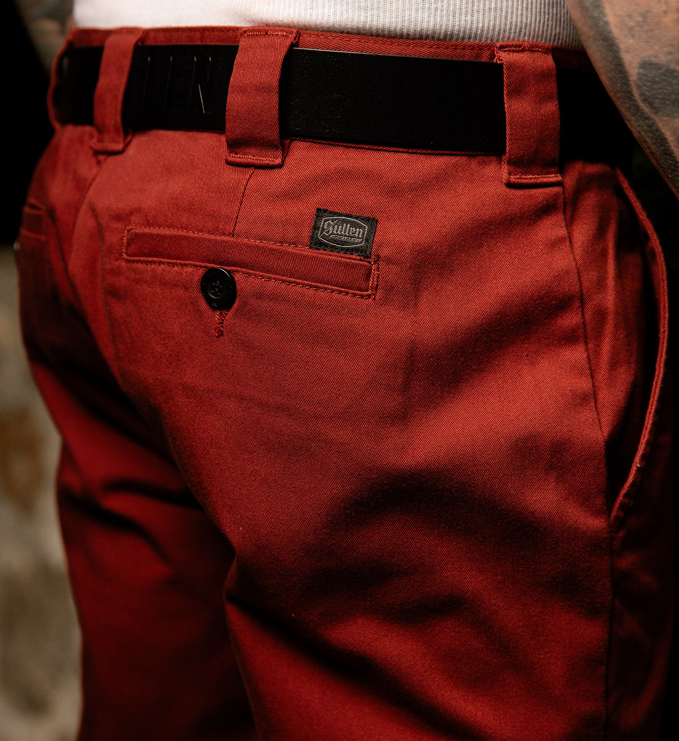 Close-up of red pants with a brand label on a blurred background