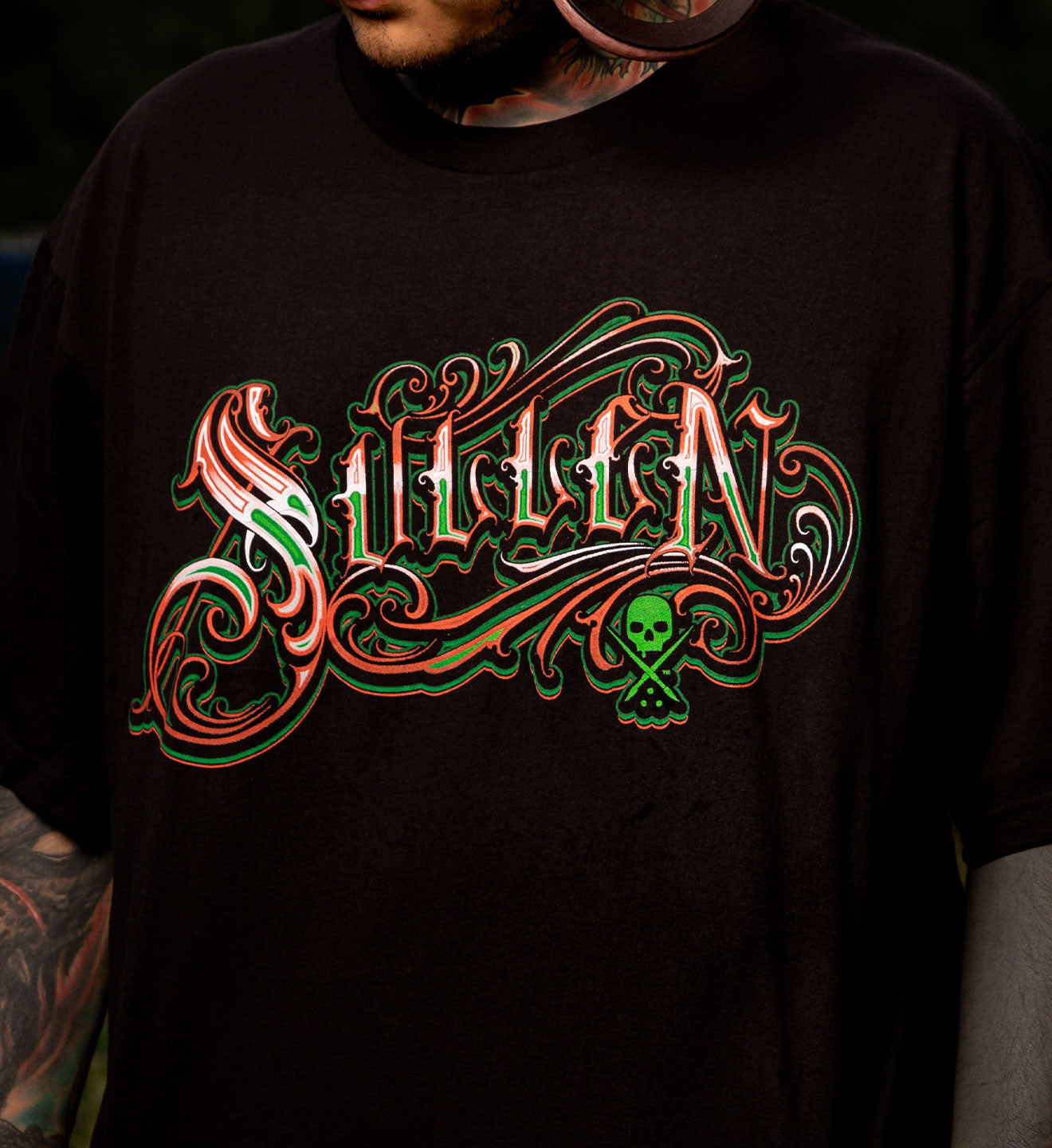 Black t-shirt with ornate 'Silent' design in red and green on a dark background