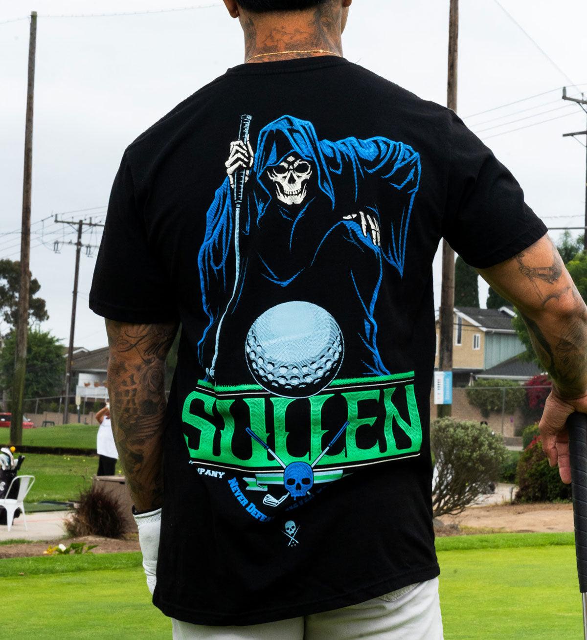 Person wearing a black t-shirt with a graphic design of a reaper holding a golf club and ball, with 'STOLEN' text.