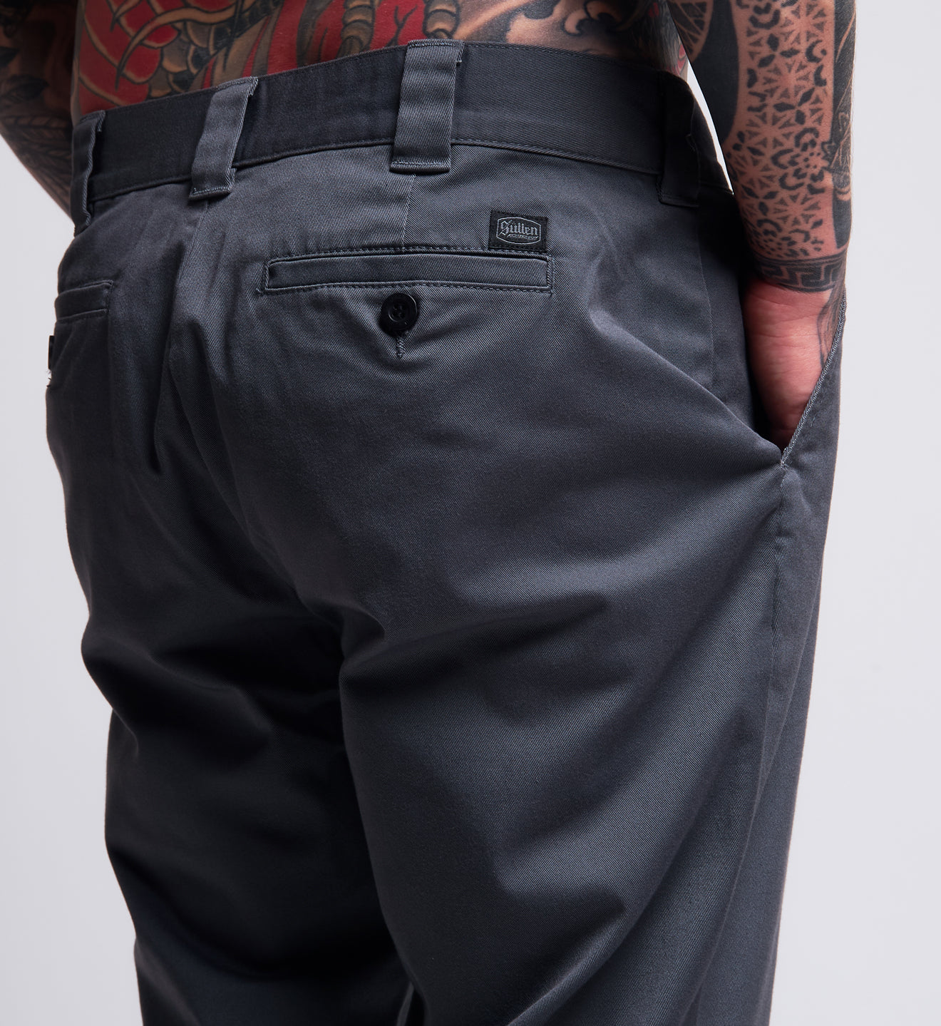 Dark gray pants with a visible brand logo on a plain background