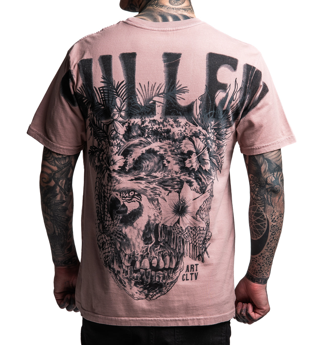 Person wearing a pink t-shirt with a black skull design on the back