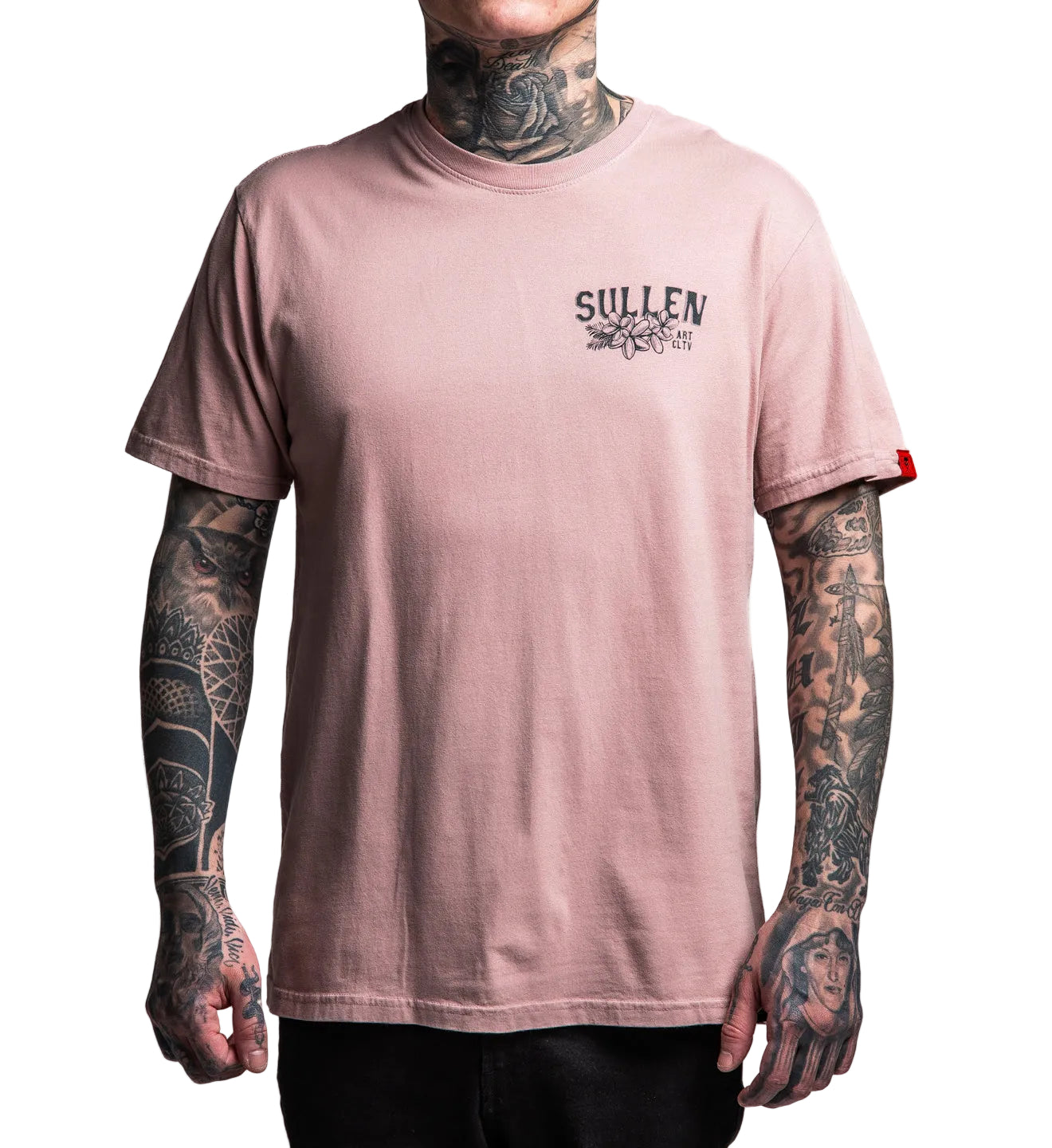 Person wearing a pink t-shirt with 'Sullen' logo and tattoos on arms, on a white background