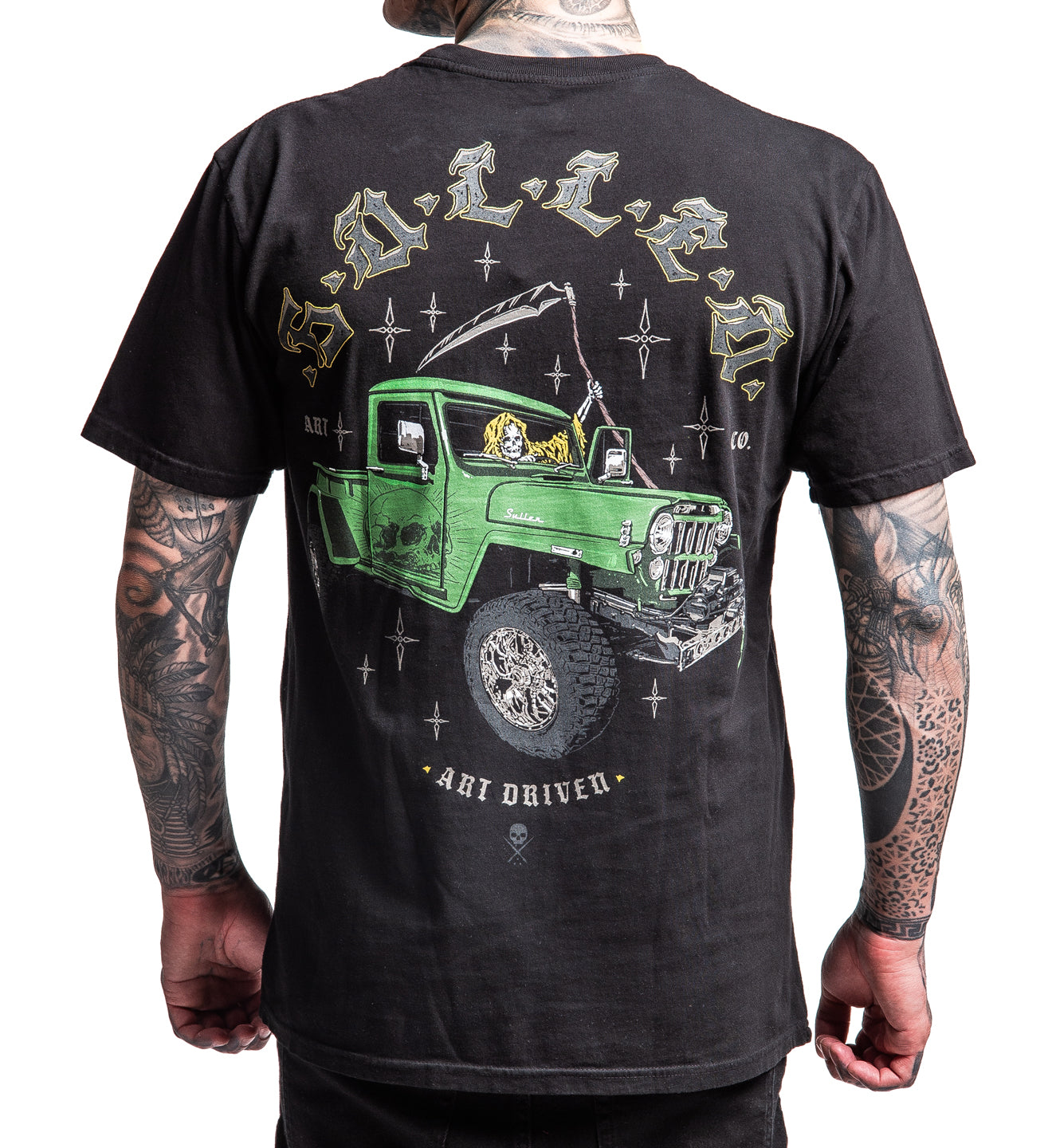 Black t-shirt with a green truck graphic on the back, worn by a person with tattoos.