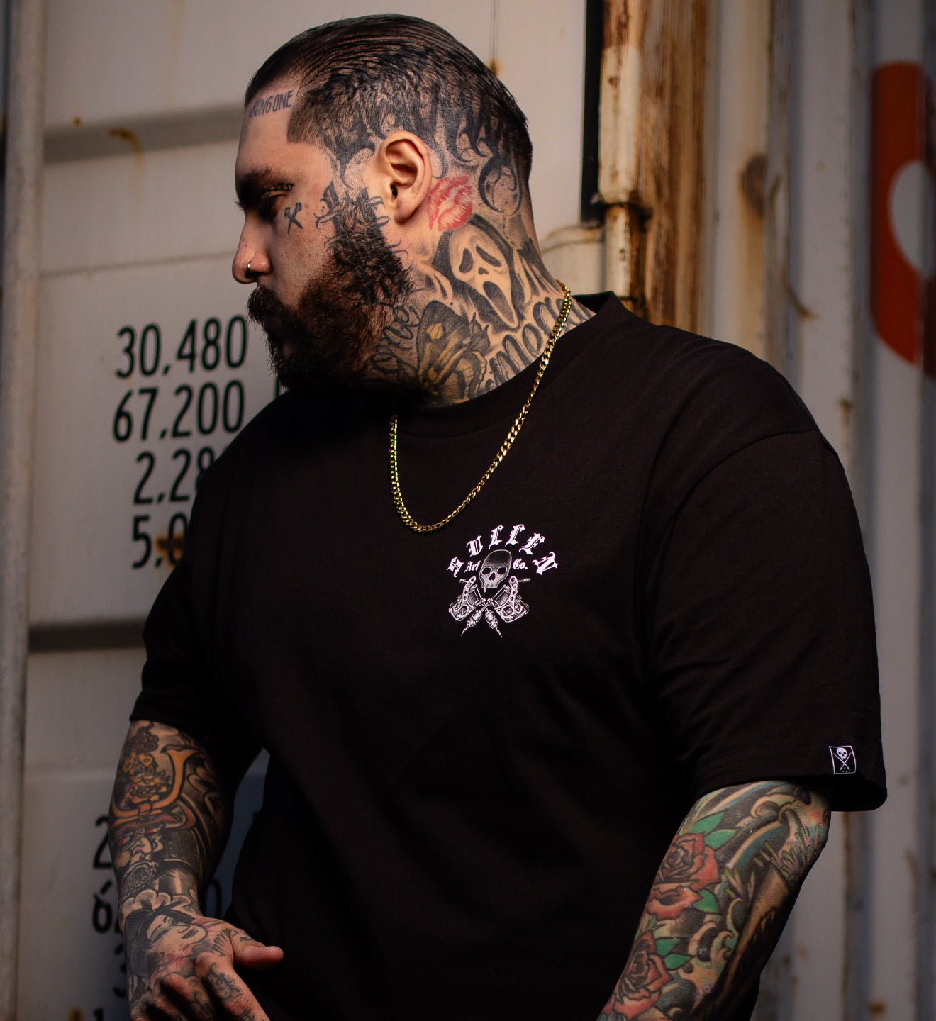 man in black tee with front left chest art print in black and grey