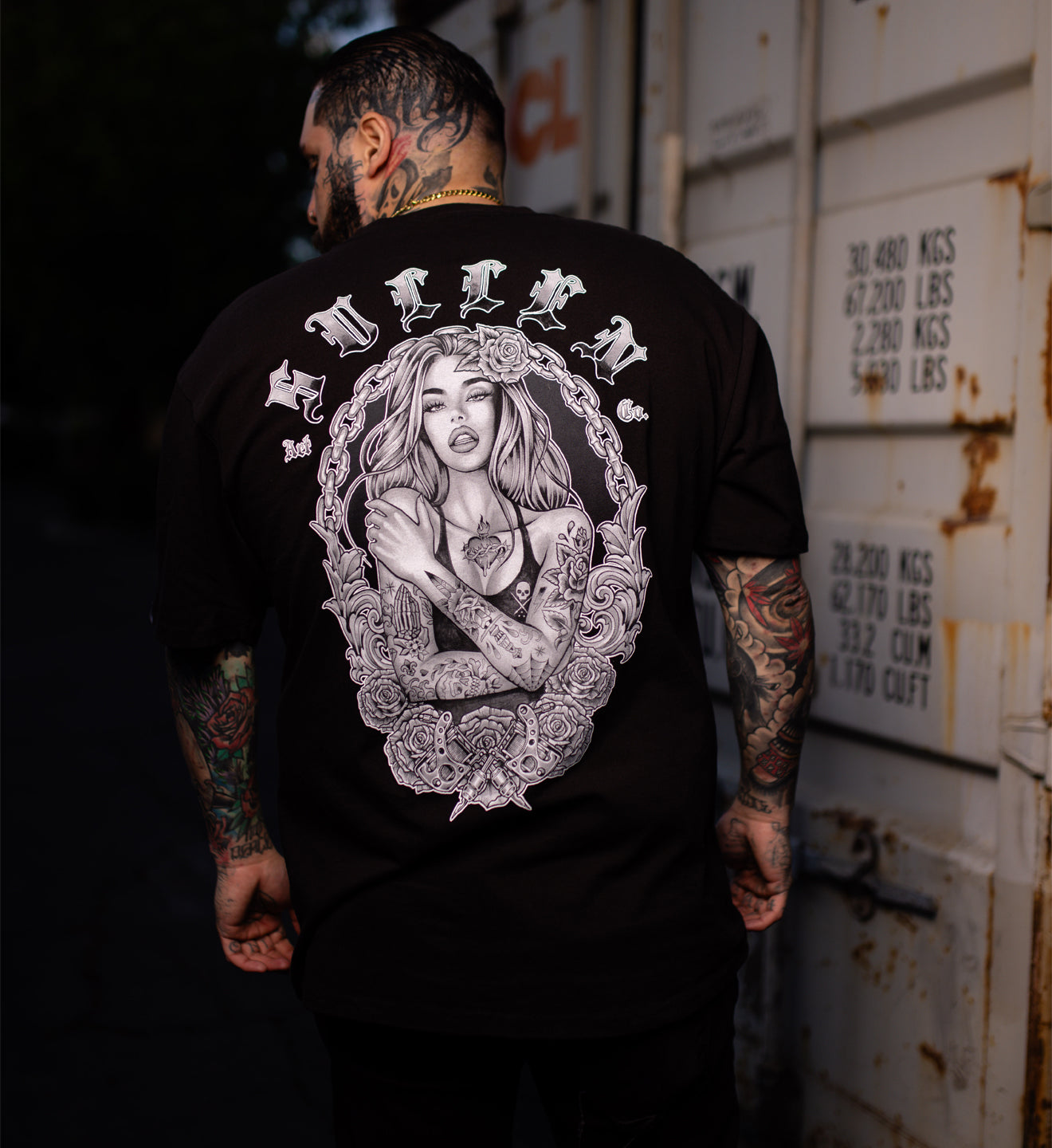 Man wearing a black tee with a pin-up girl on the back in black and grey