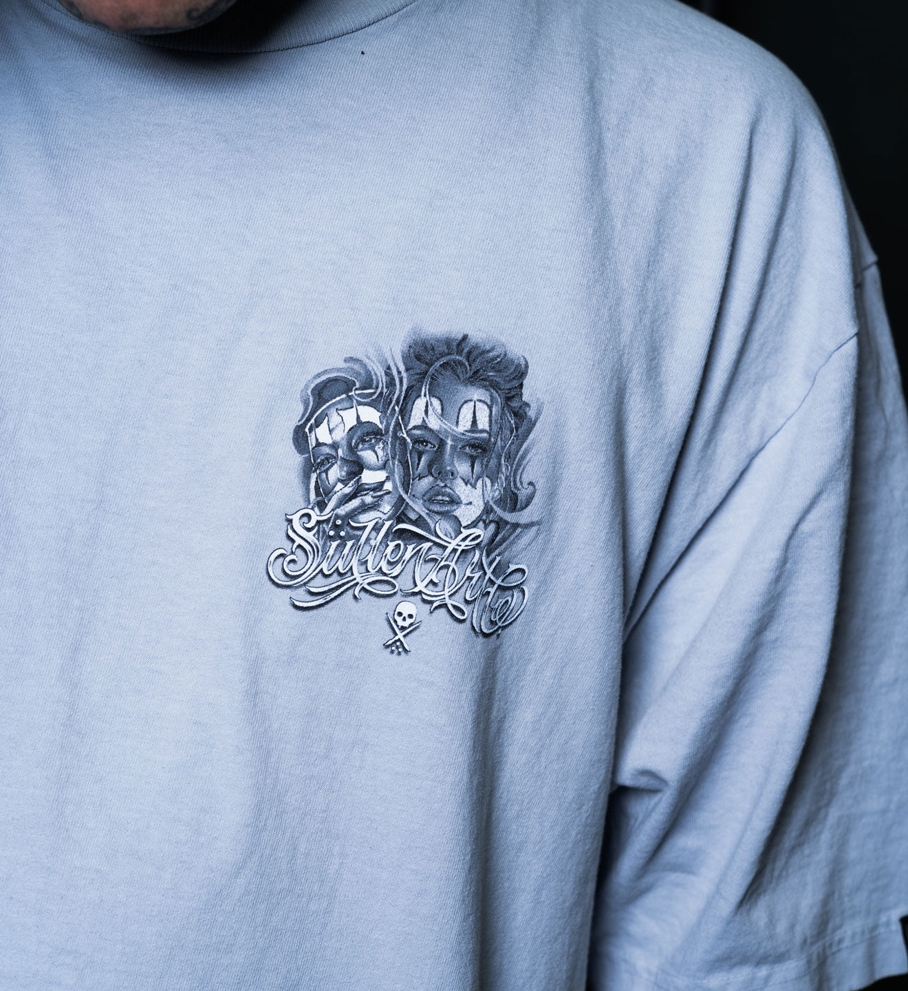 Light blue t-shirt with graphic design and text on a plain background