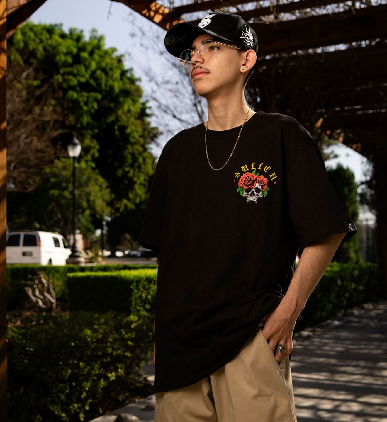 Person wearing a black t-shirt with a colorful graphic design outdoors.