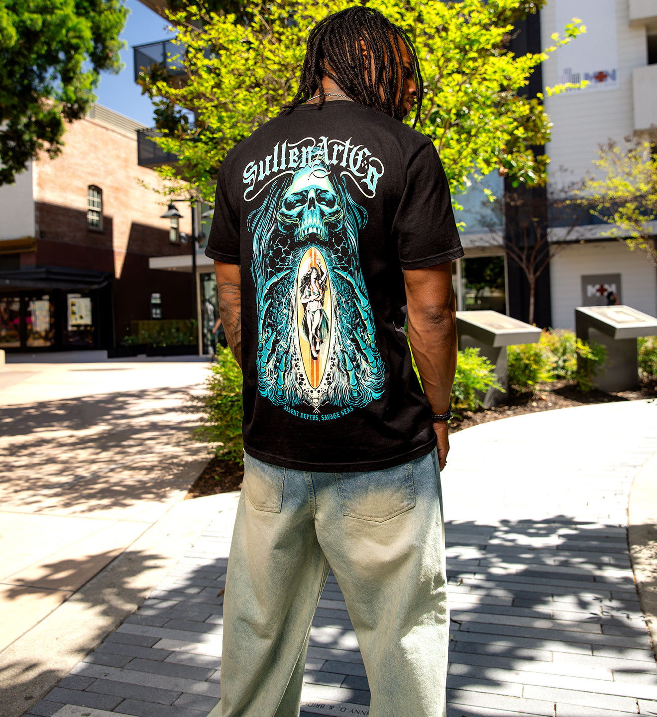 Person wearing a black t-shirt with a graphic design outdoors