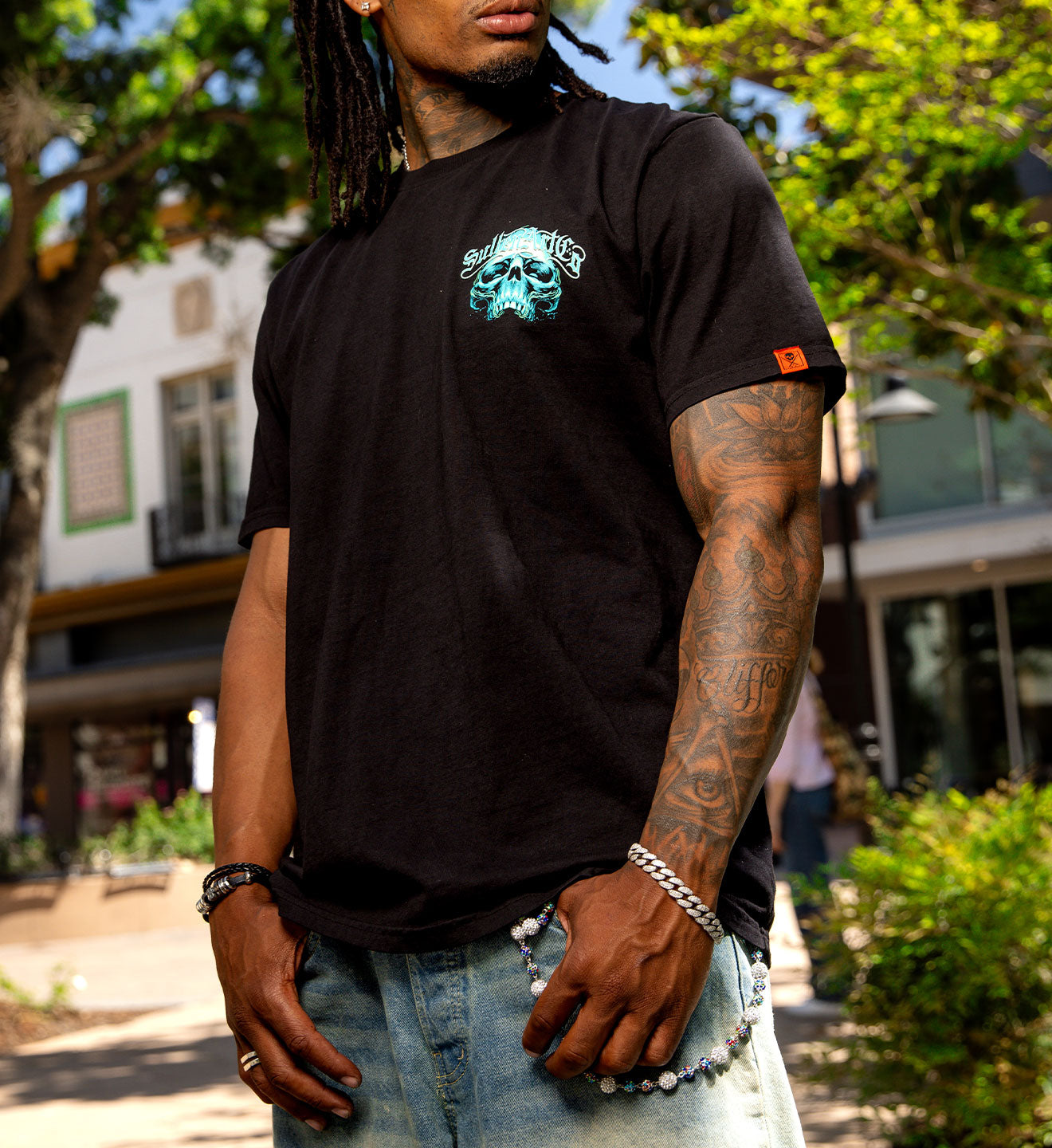Man wearing a black t-shirt with a graphic design, standing outdoors.