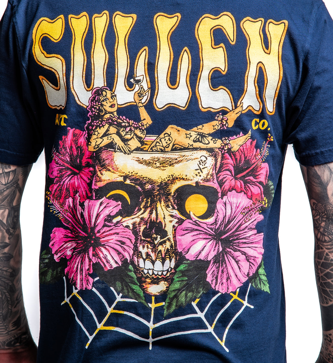 T-shirt with a skull and floral design featuring the brand 'Sullen' on a blue background.