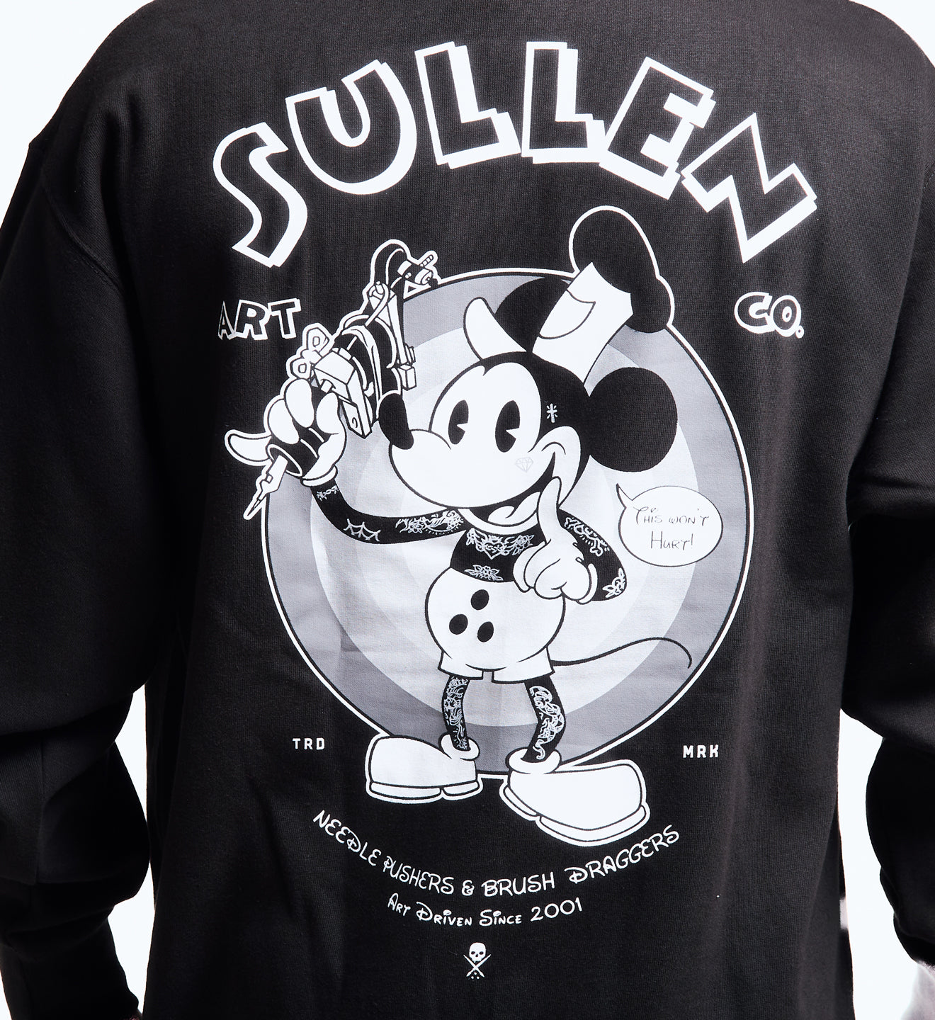 Black long-sleeve shirt with a graphic design featuring a stylized character and 'Sullen' branding.