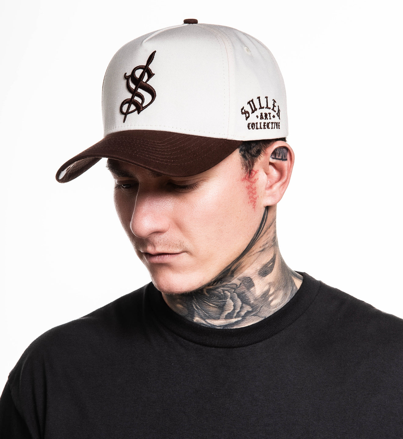 Man wearing a cap with a logo and text, against a white background