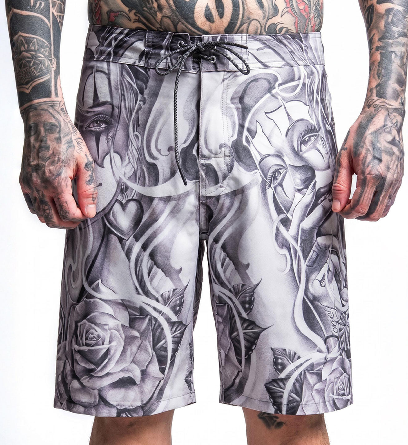 Person wearing black and white tattoo-style shorts with visible tattoos on arms.