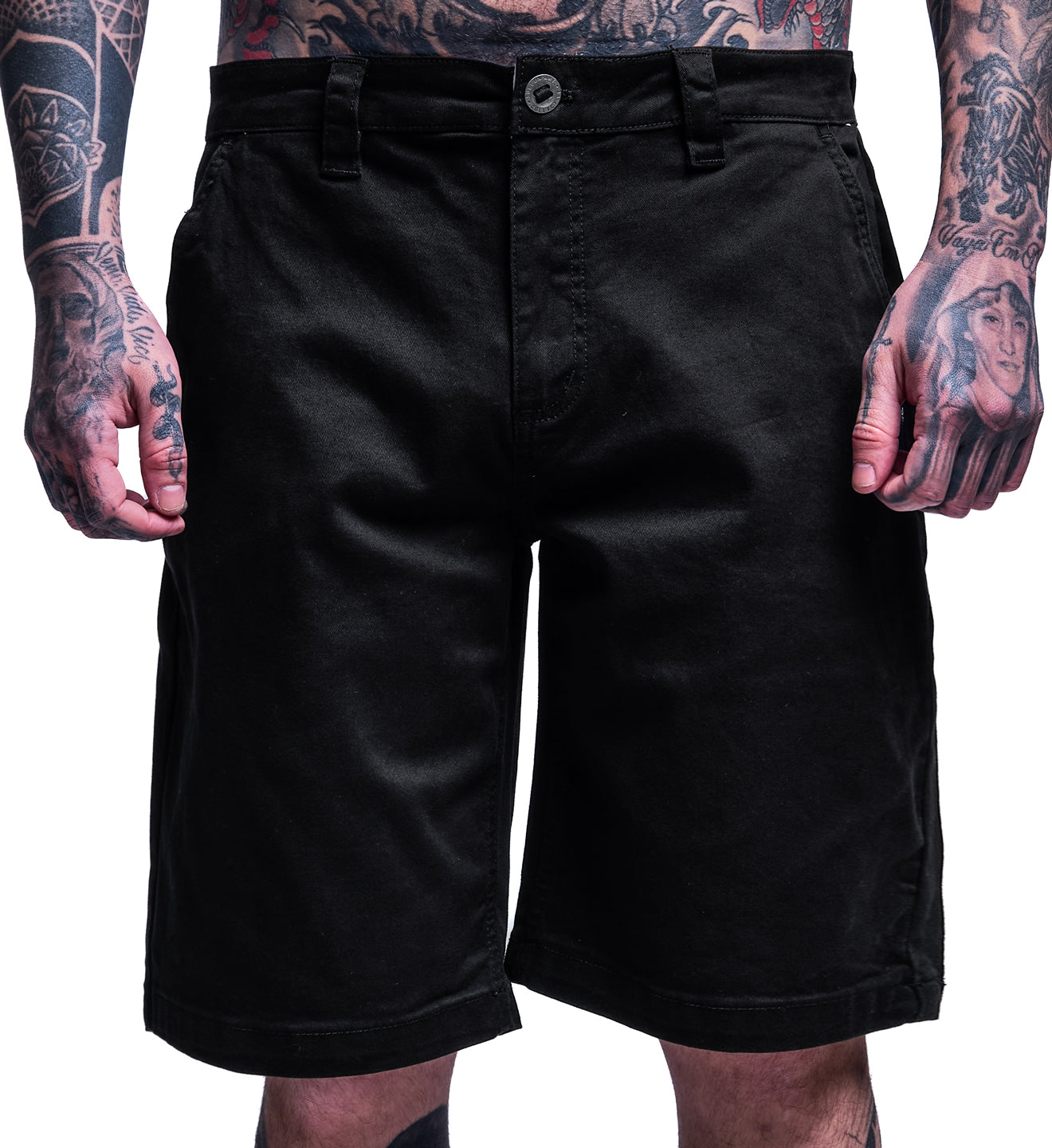 Black shorts worn by a person with tattoos on a white background