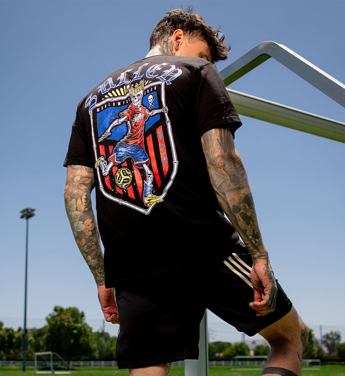 Person wearing a black t-shirt with a colorful graphic on the back, standing outdoors.