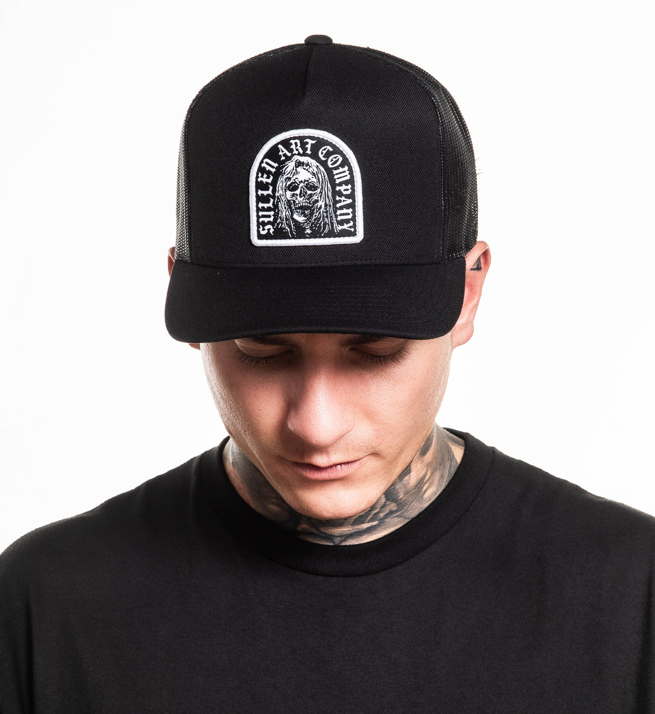 Person wearing a black cap with a logo on a white background