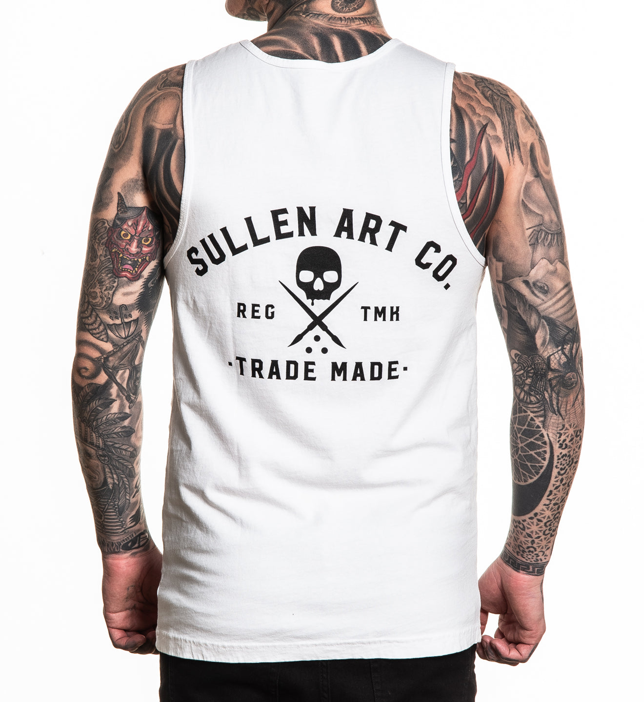 Person wearing a white sleeveless shirt with 'Sullen Art Co.' logo and tattoos on arms