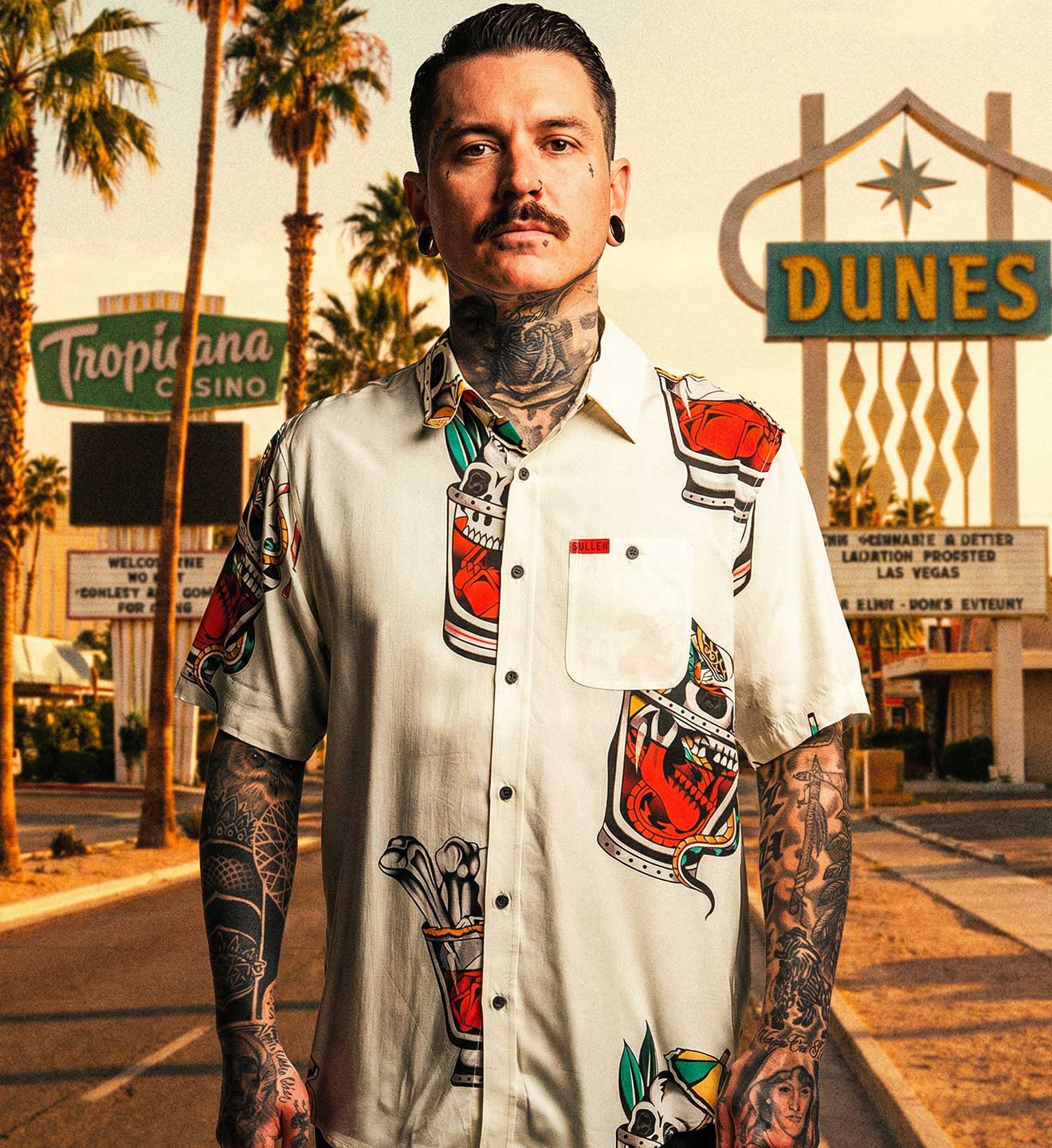Man with tattoos standing in front of a Las Vegas casino sign