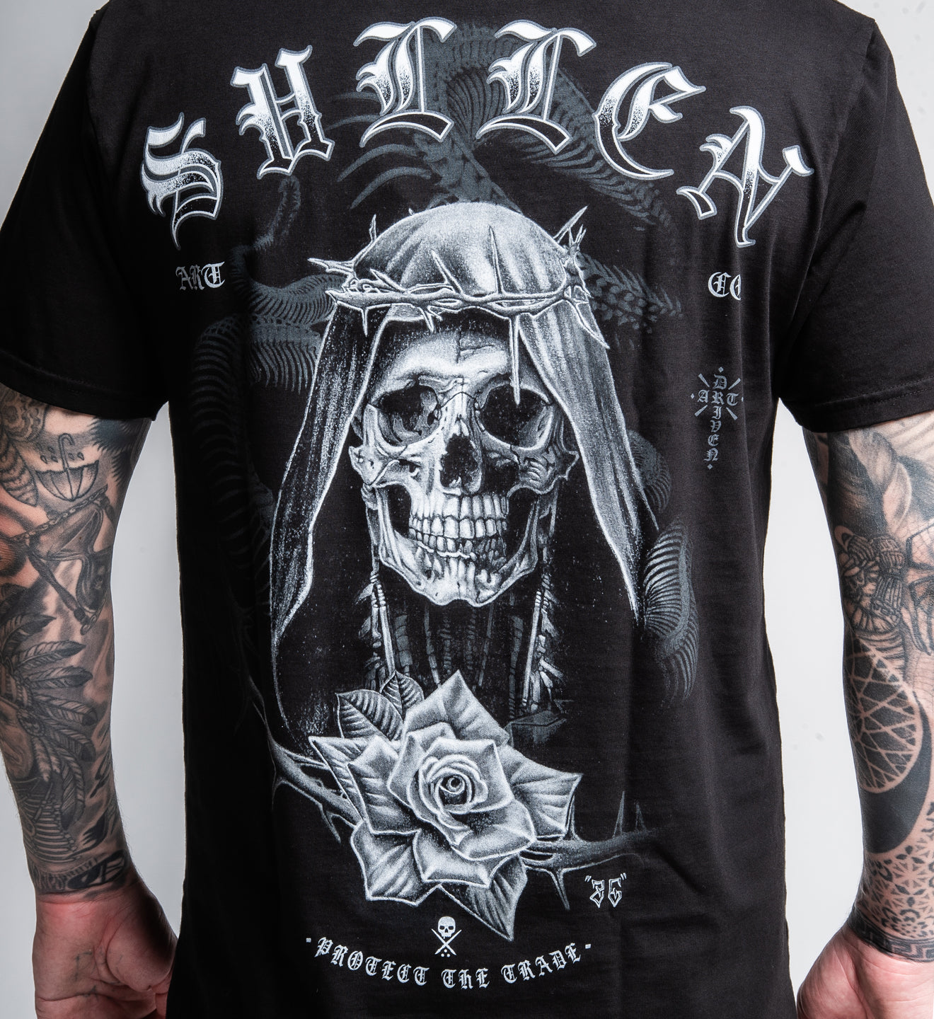 Black t-shirt with a skull and rose design on the back, featuring the brand 'Sullen'.