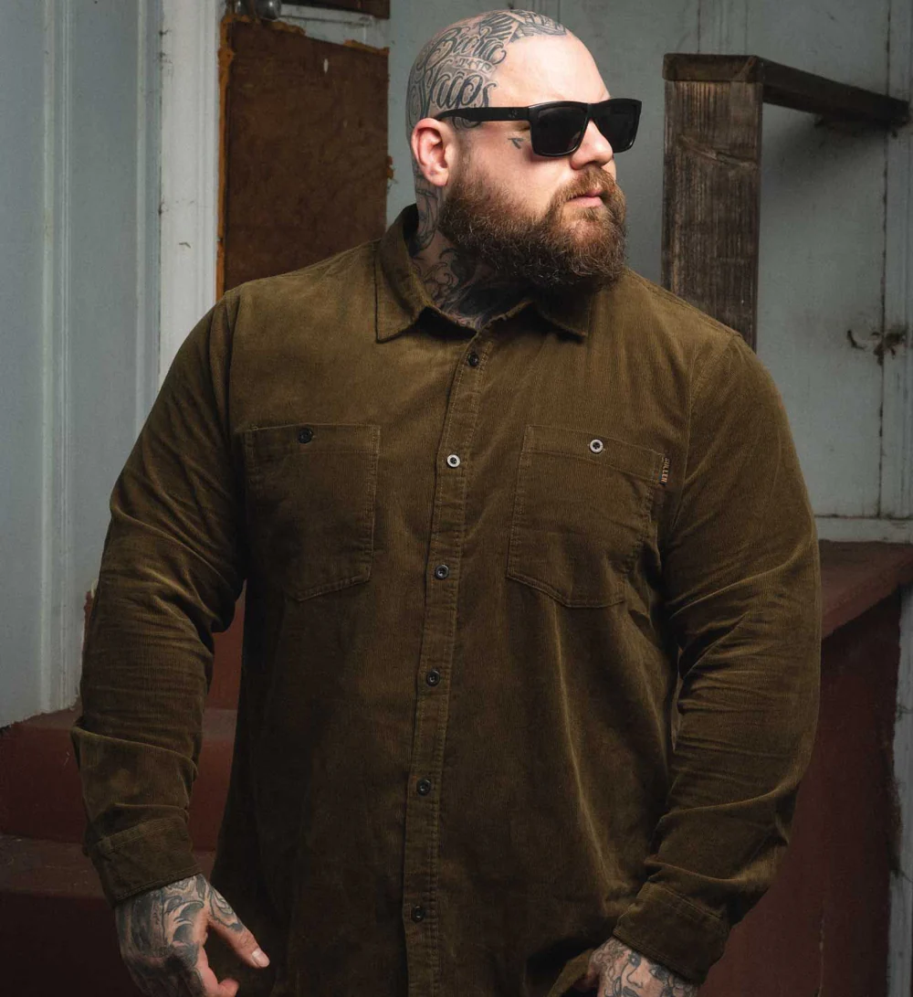 man with tattoos wearing a textured button up shirt