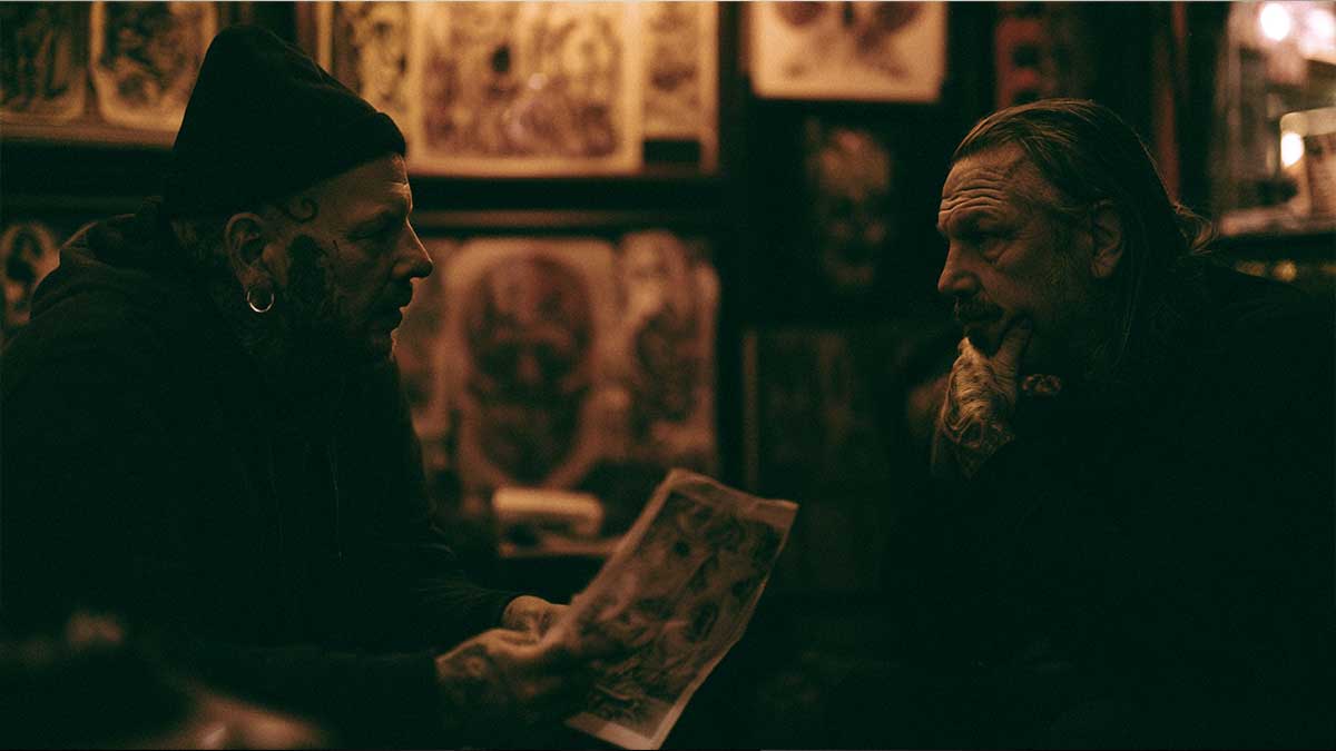 A tattoo artist and client reviewing reference art before a tattoo session — what to know, ask, and prepare before you get tattooed