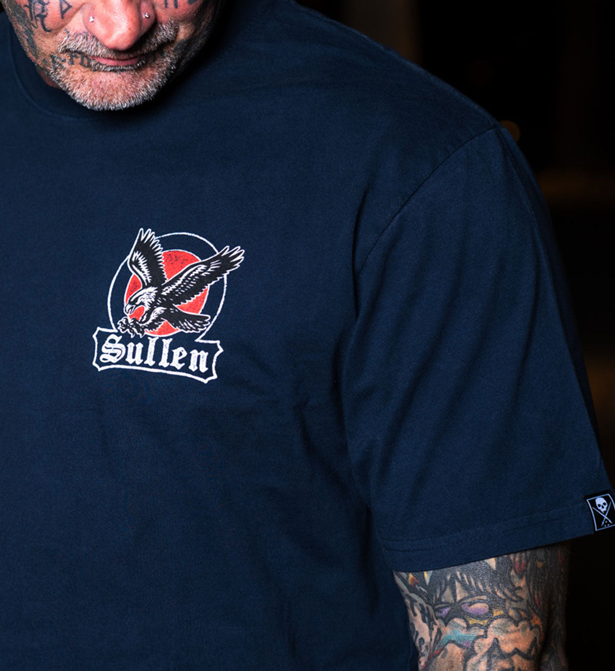 Navy blue t-shirt with a logo featuring an eagle and 'Sullen' text on a dark background.