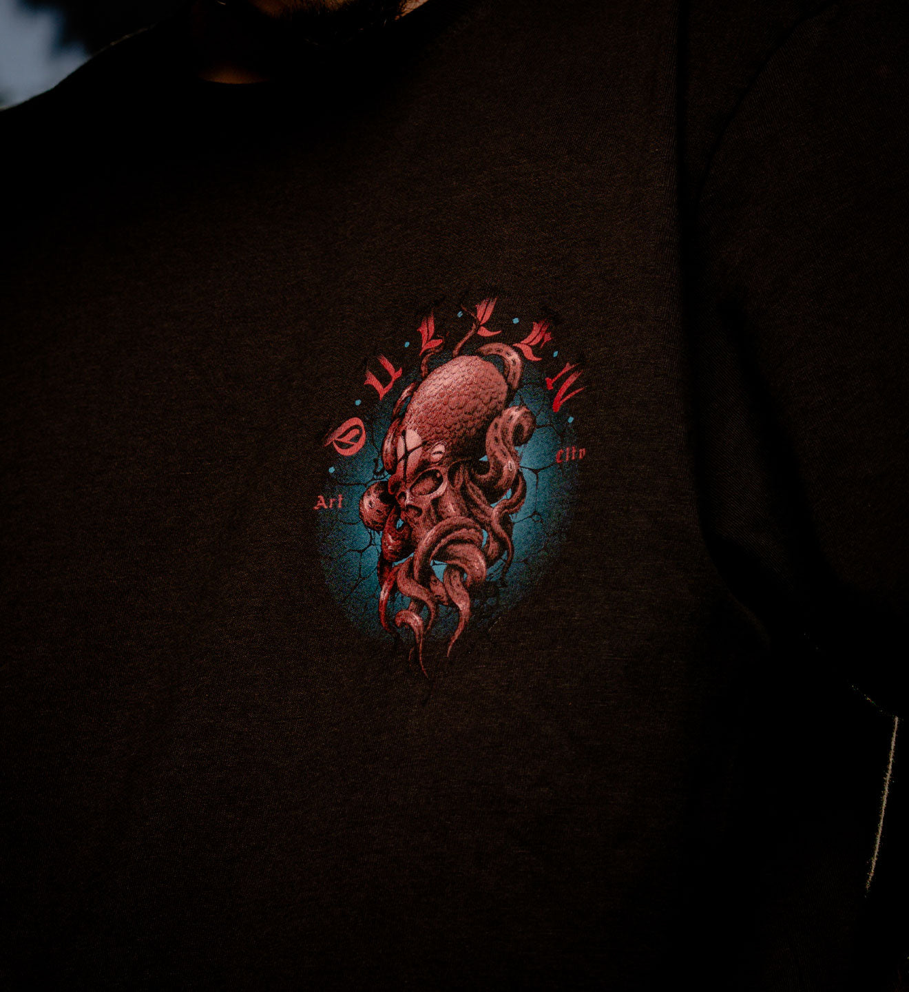 Dark t-shirt with a red octopus design and text on a dark background