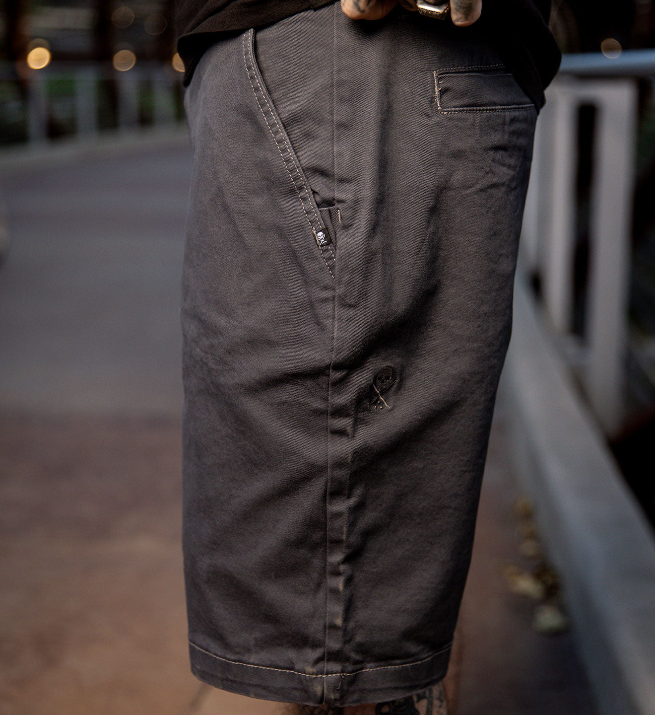 Dark gray pants worn by a person with a blurred background