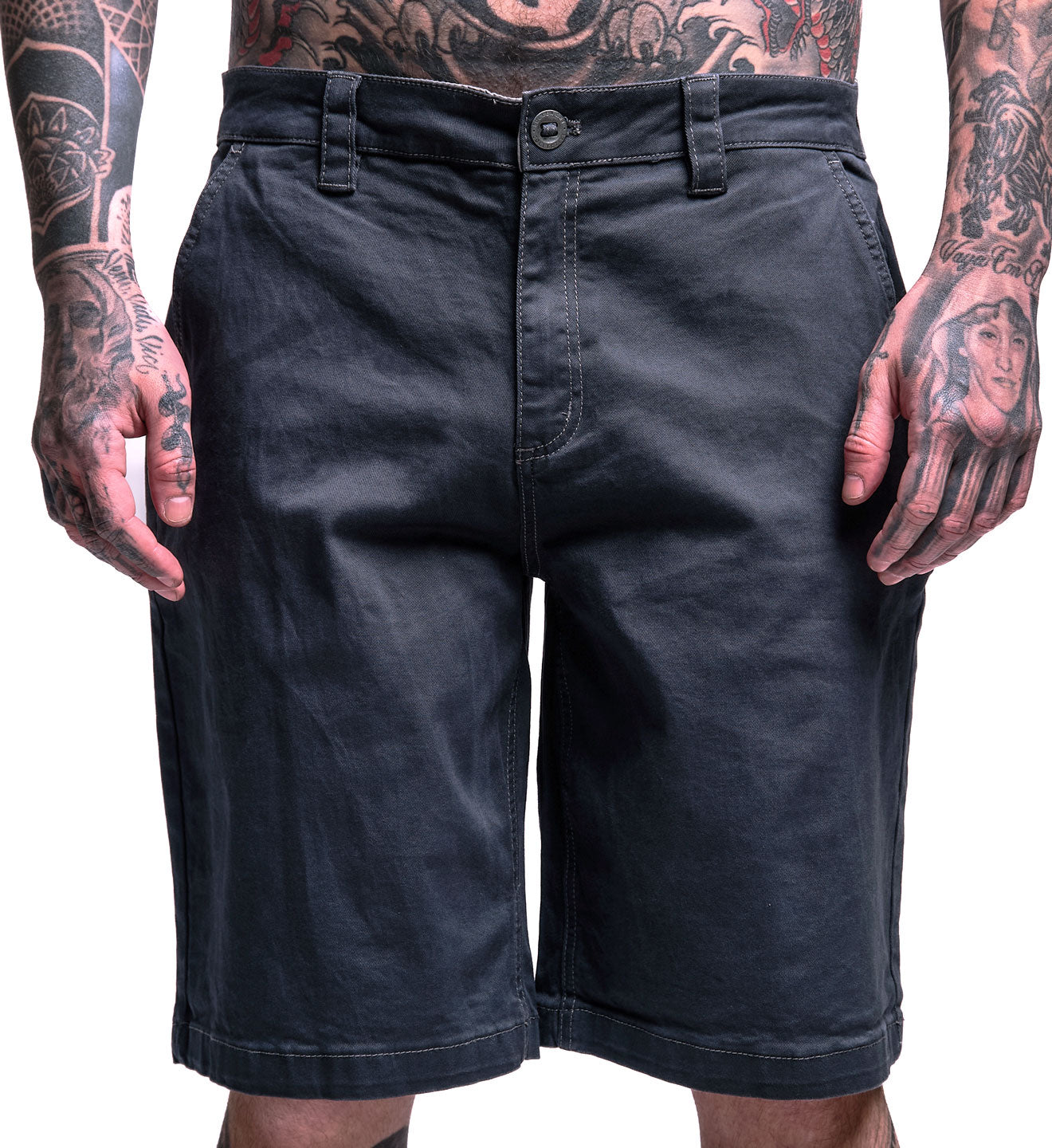 Person wearing black shorts with tattooed arms on a white background