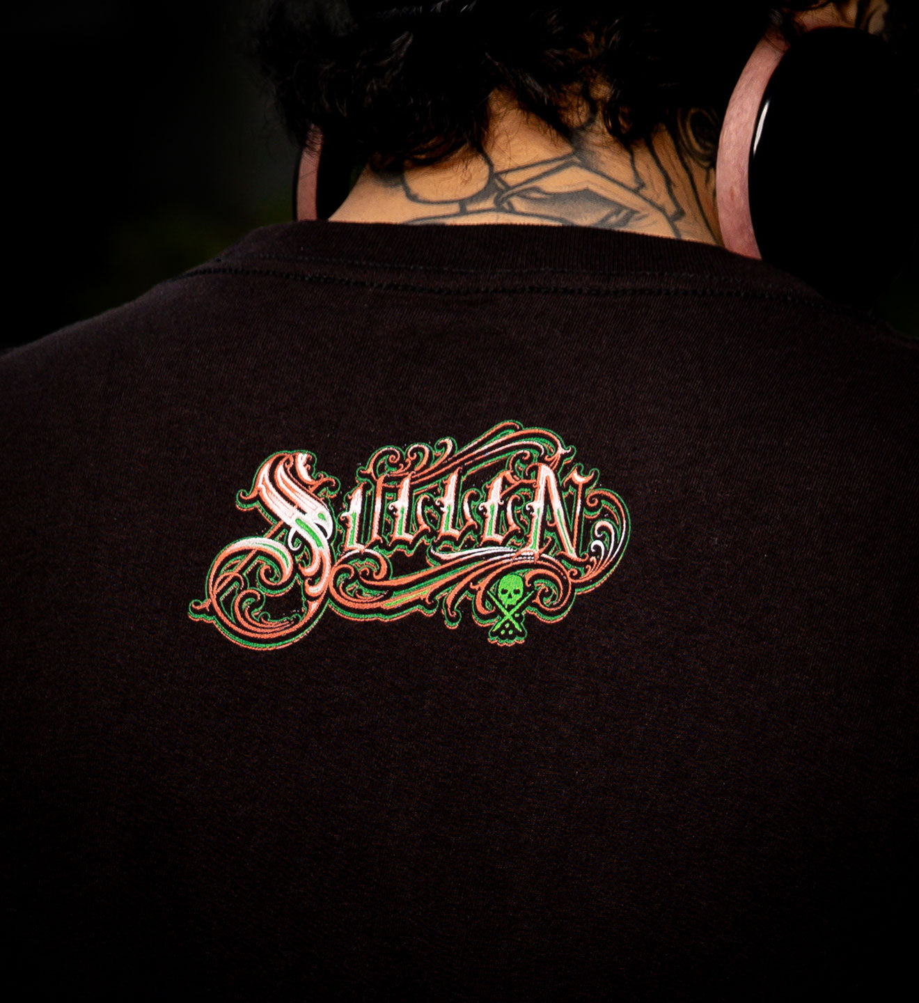 Black t-shirt with 'Suffoc' logo on the back, worn by a person.