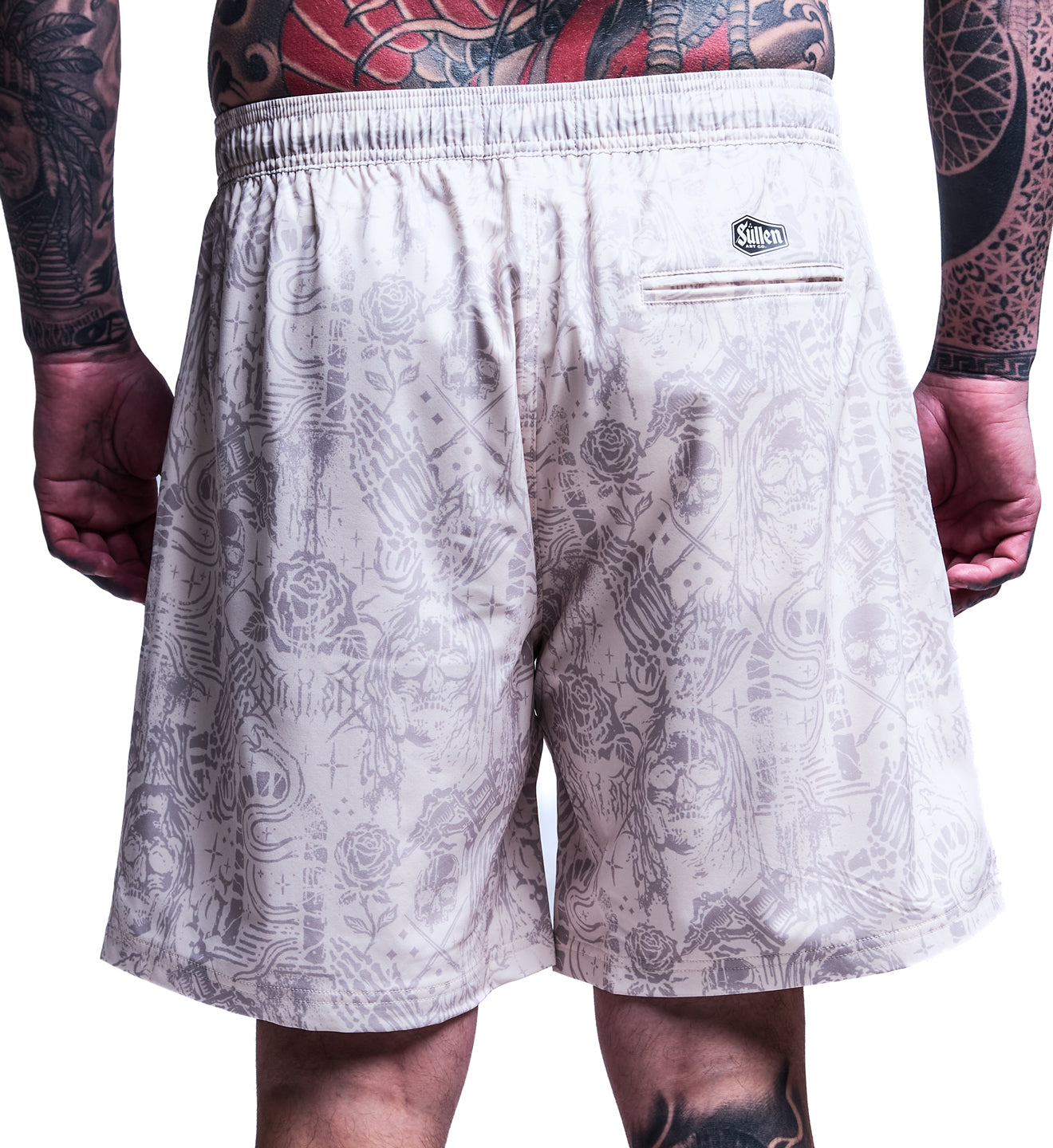 Patterned shorts worn by a person with tattoos on a white background
