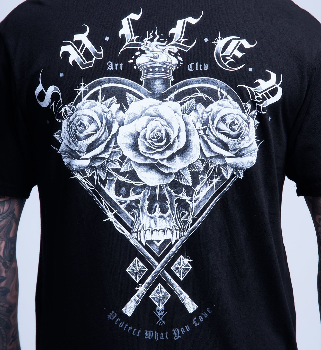 Black t-shirt with white skull and roses design on a plain background