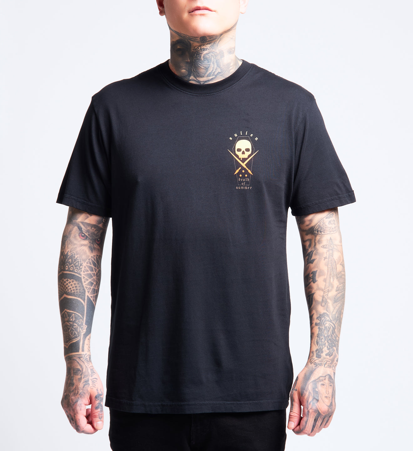 Person wearing a black t-shirt with a skull and crossbones design on a plain background