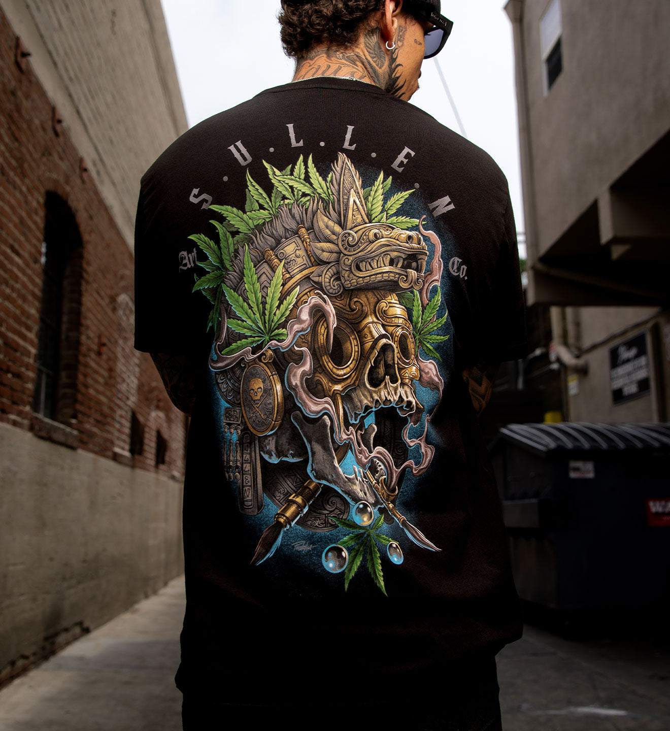 Person wearing a black t-shirt with a colorful graphic design in an urban setting