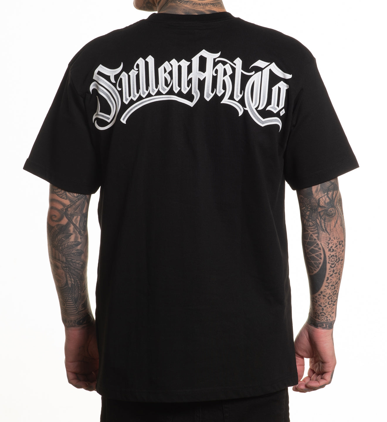 Black t-shirt with white text on the back worn by a person with tattoos.