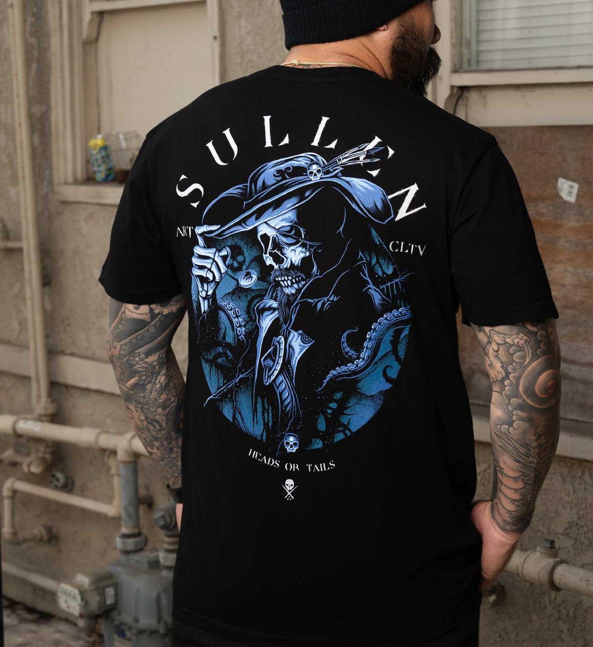 sullen tattoo lifestyle pirate day capsule 2026 tee heads or tails. Dark skull artwork printed on black mens short sleeve tee