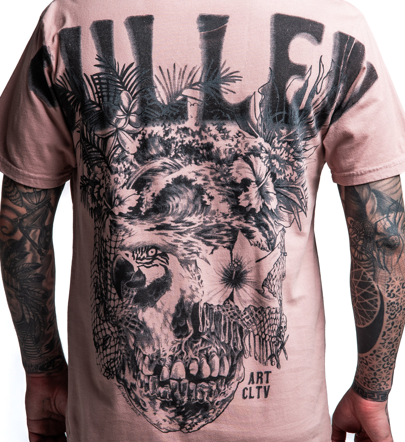 T-shirt with a skull and floral design on a person with tattoos.