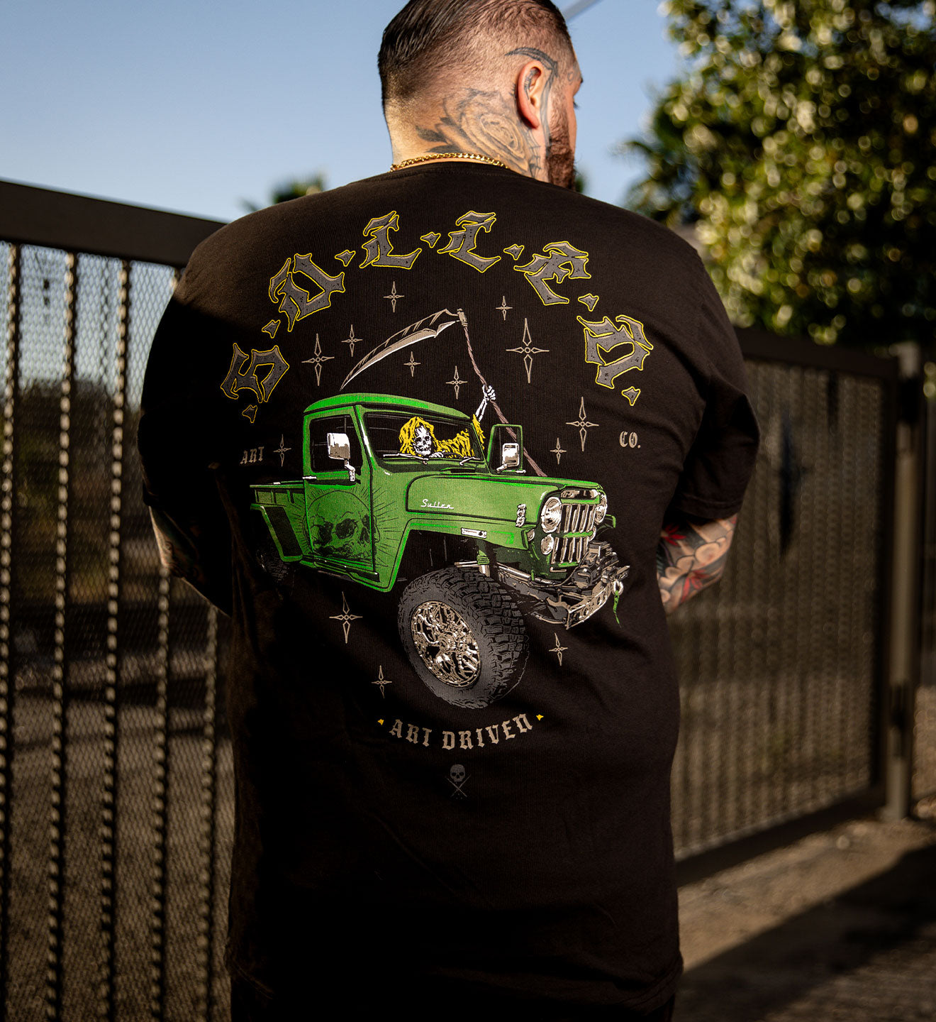 MODEL WEARING A BLACK SULLEN PREMIUM TEE WITH A REAPER DRIVING A JEEP GRAPHIC 