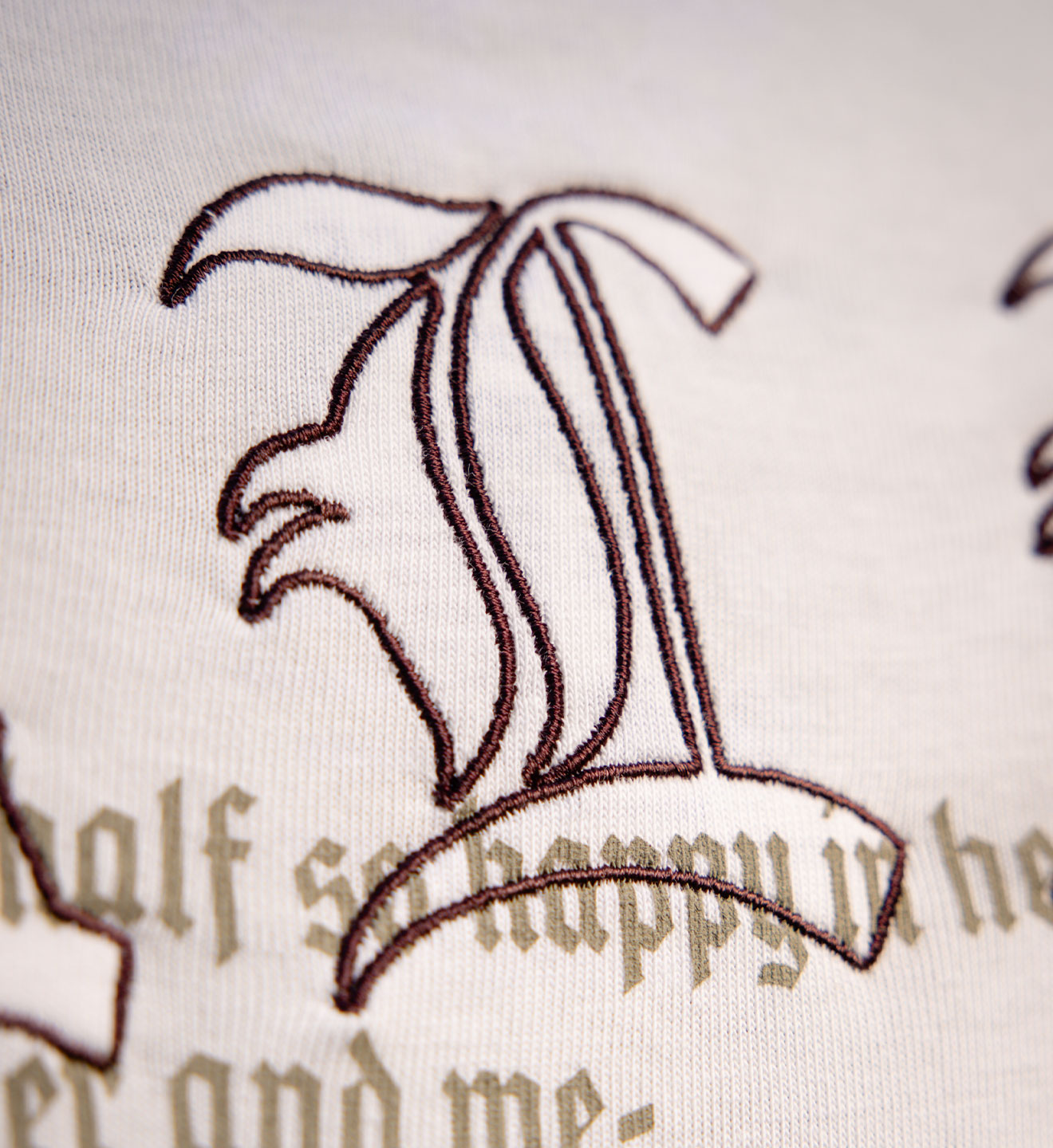 Embroidered design on fabric with text 'half so happy in her and me'.