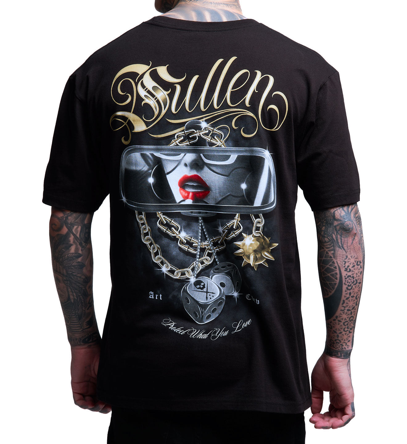 Black t-shirt with a graphic design on the back featuring a face with red lips and various charms, displayed by a person.