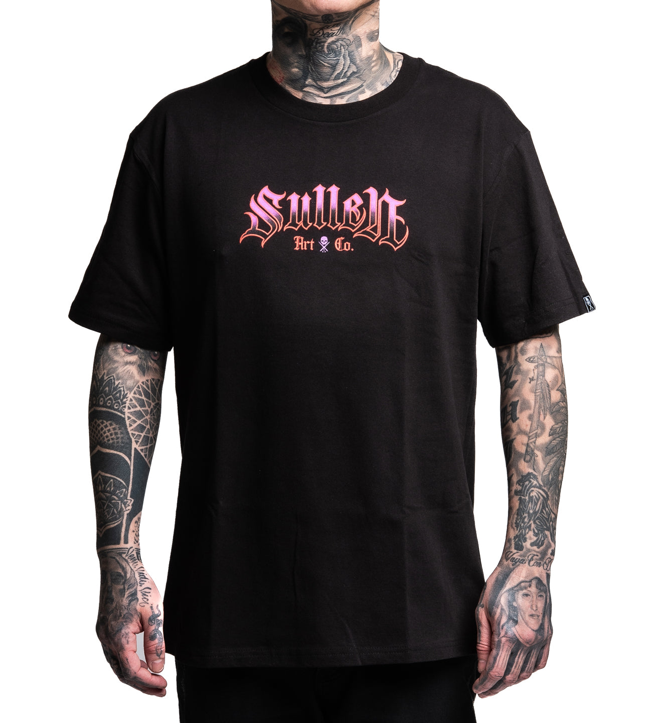 Person wearing a black t-shirt with 'Sullen Art Co.' logo, tattoos visible on arms.