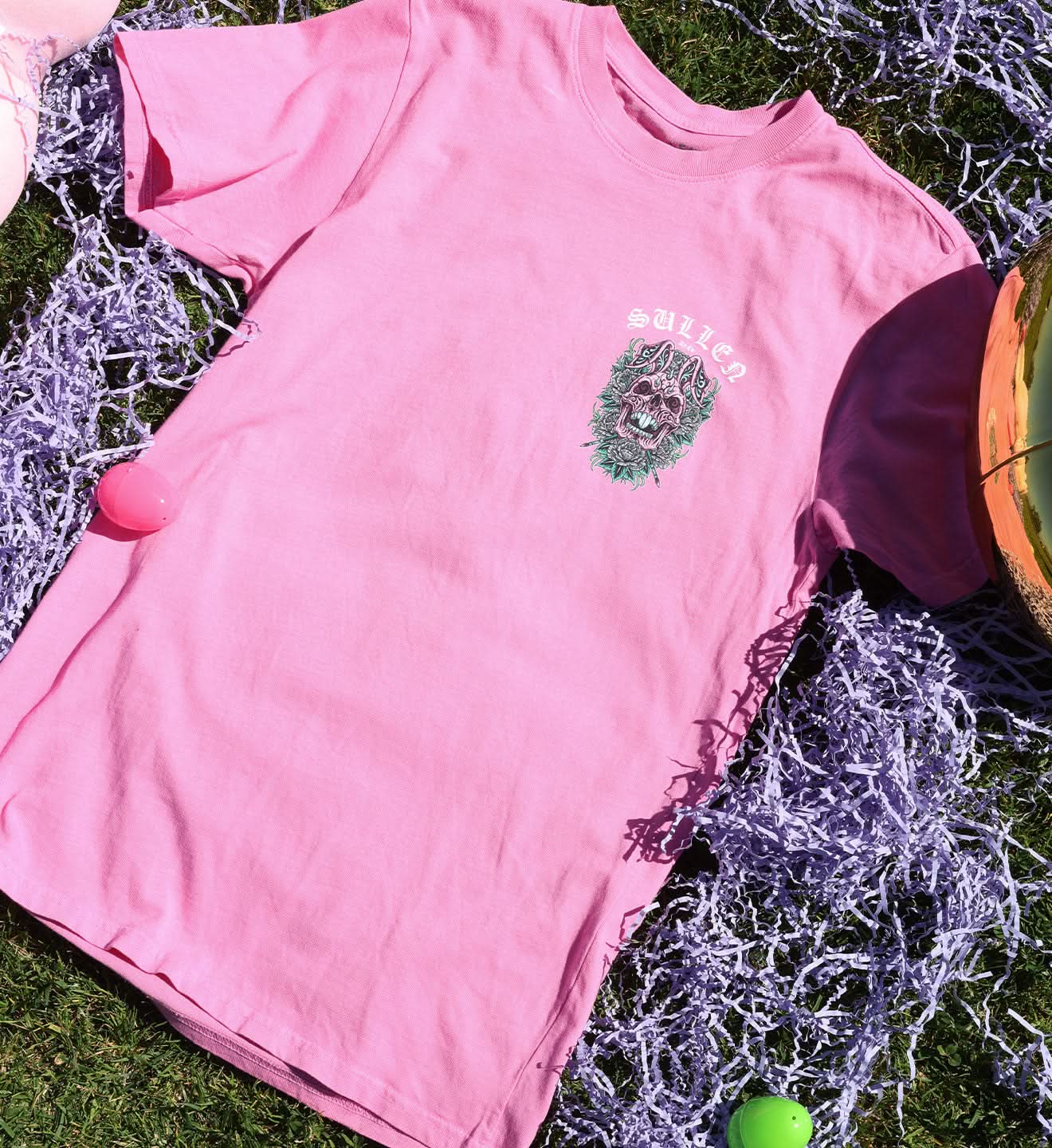 Pink t-shirt with a graphic design on grass