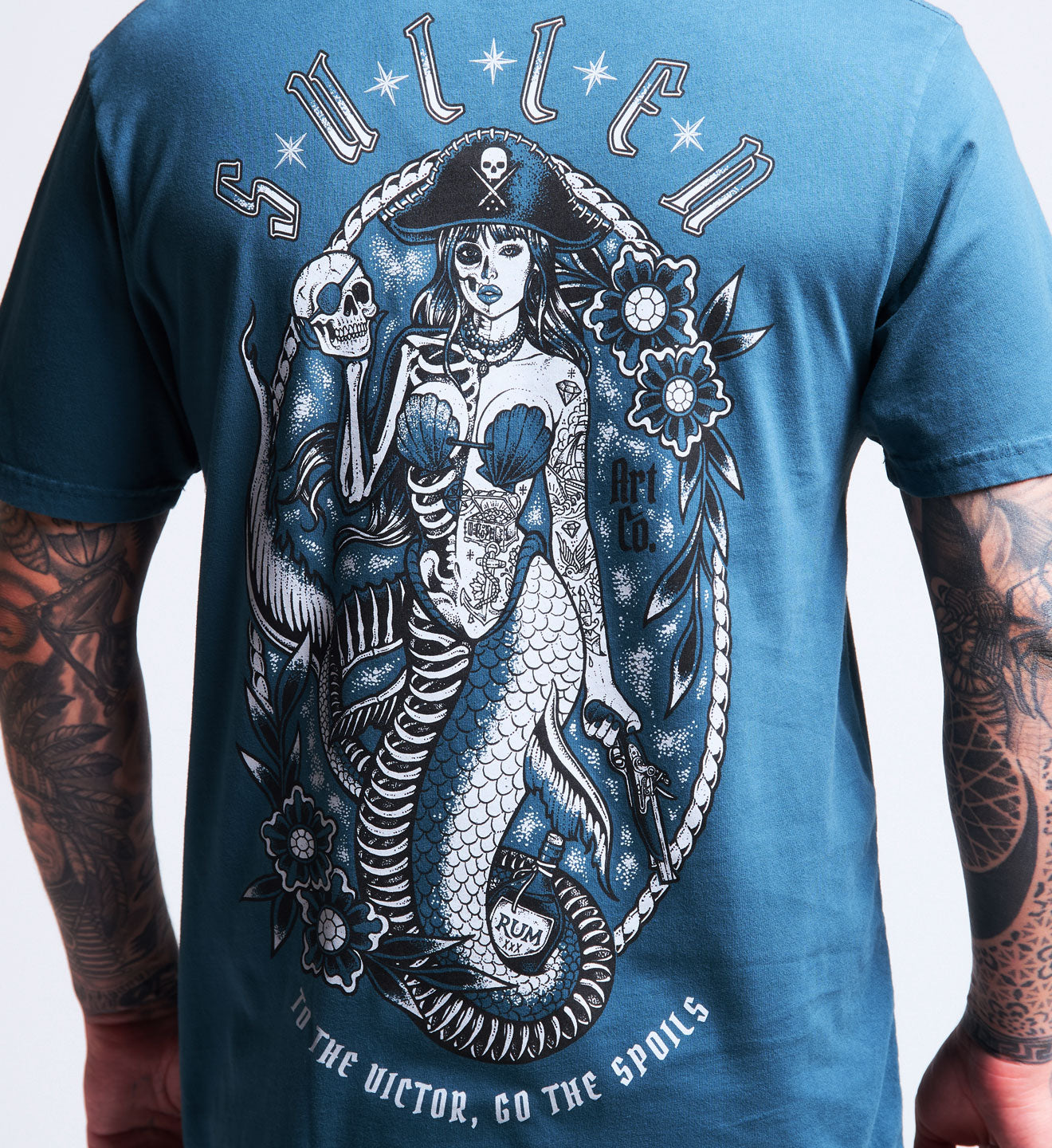 Blue t-shirt with a mermaid and pirate design on a plain background