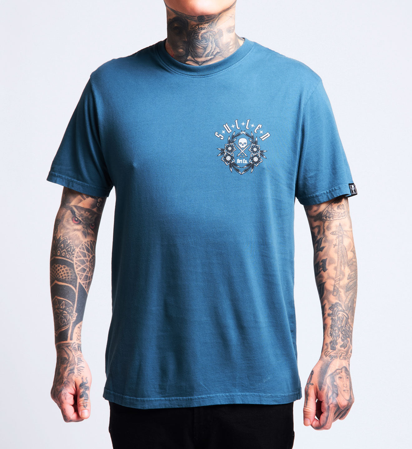 Person wearing a blue t-shirt with a logo on a plain background